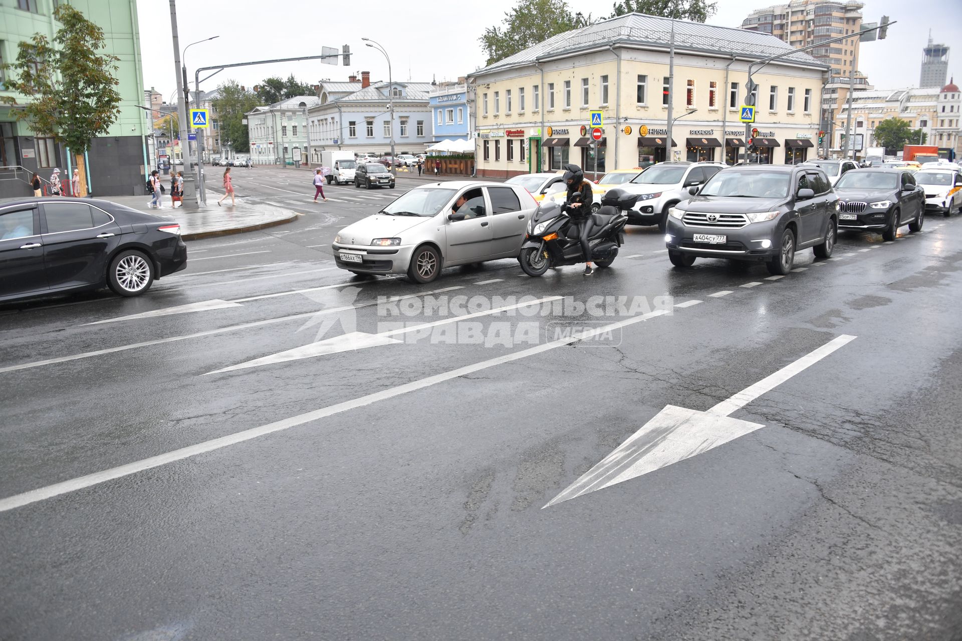 Москва. Мотоциклист и машины едут по дороге.