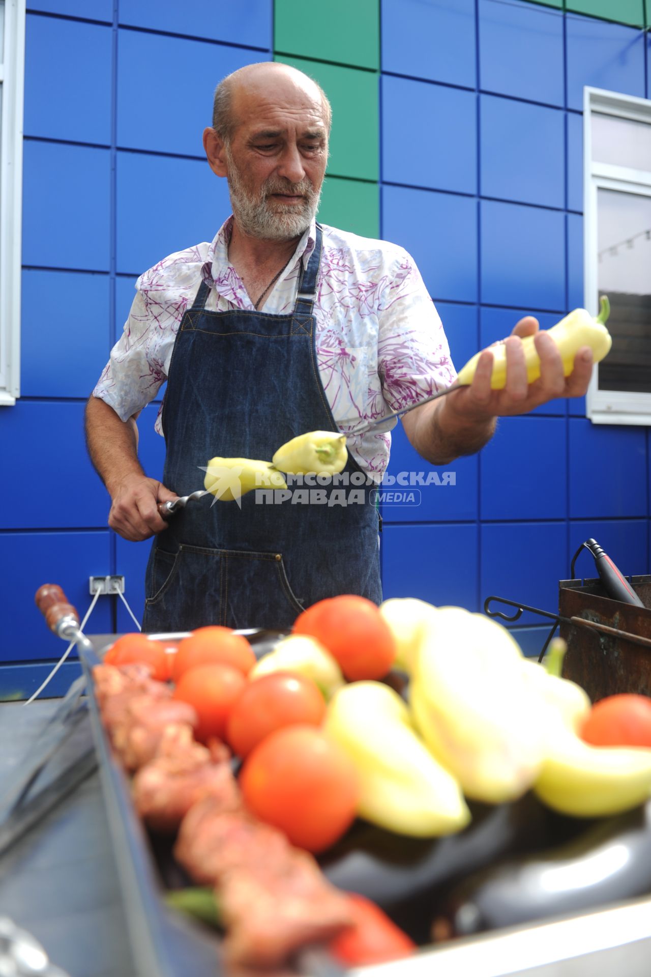 Санкт-Петербург. Шашлычник нанизывает перец на шампур на Южном рынке.