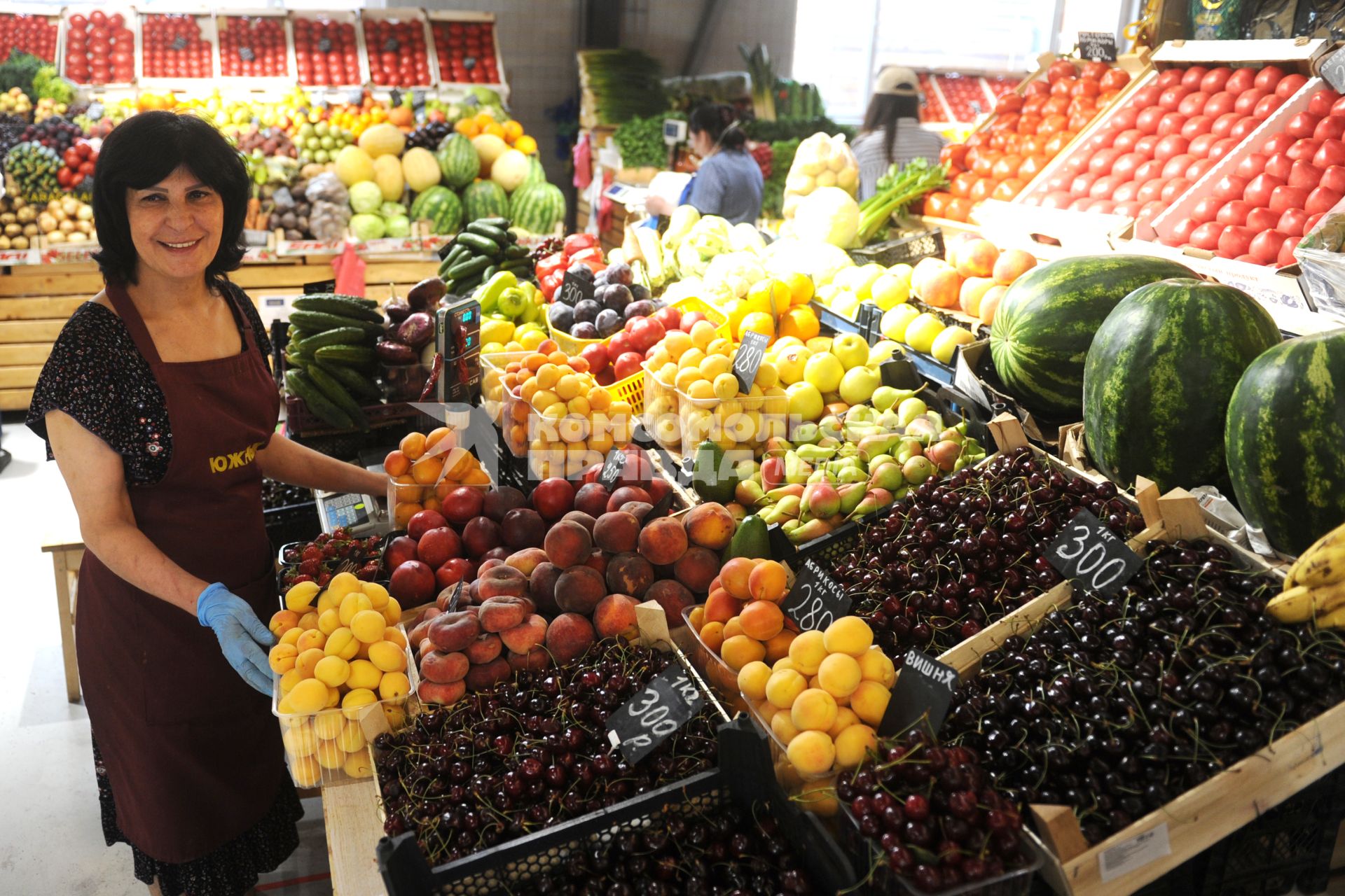 Санкт-Петербург. Продавщица у прилавка с фруктами и ягодами на Южном рынке.
