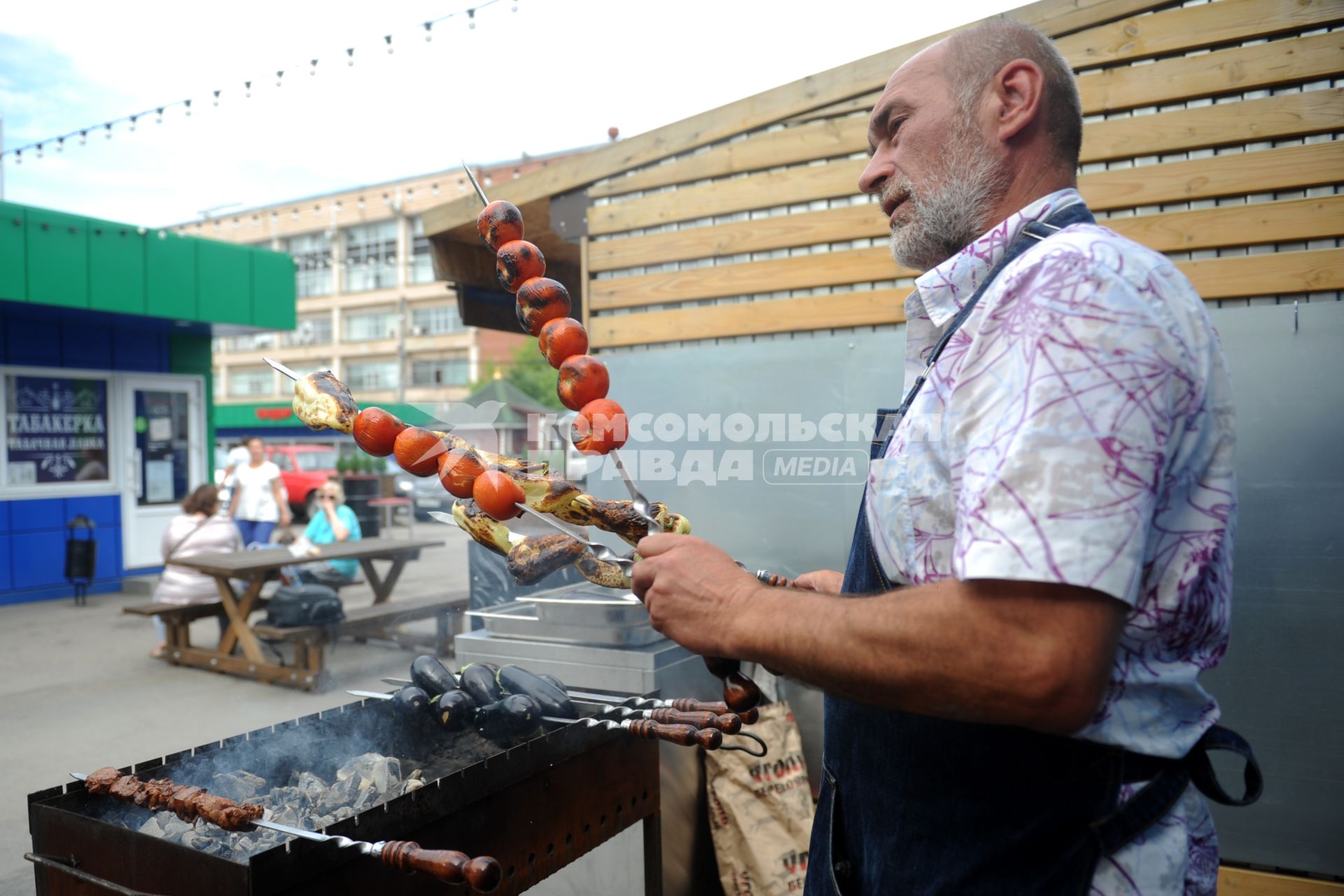 Санкт-Петербург. Южный рынок. Шашлычник жарит мясо и овощи на мангале.