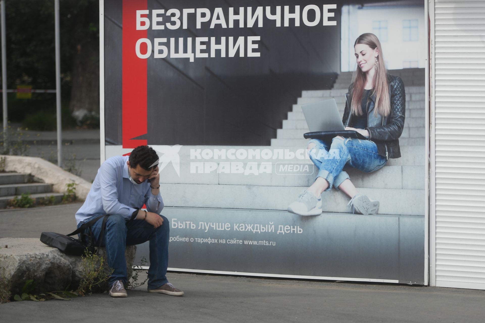 Екатеринбург. Мужчина говорит по телефону у рекламного плаката МТС, с надписью \'Безграничное общение\'
