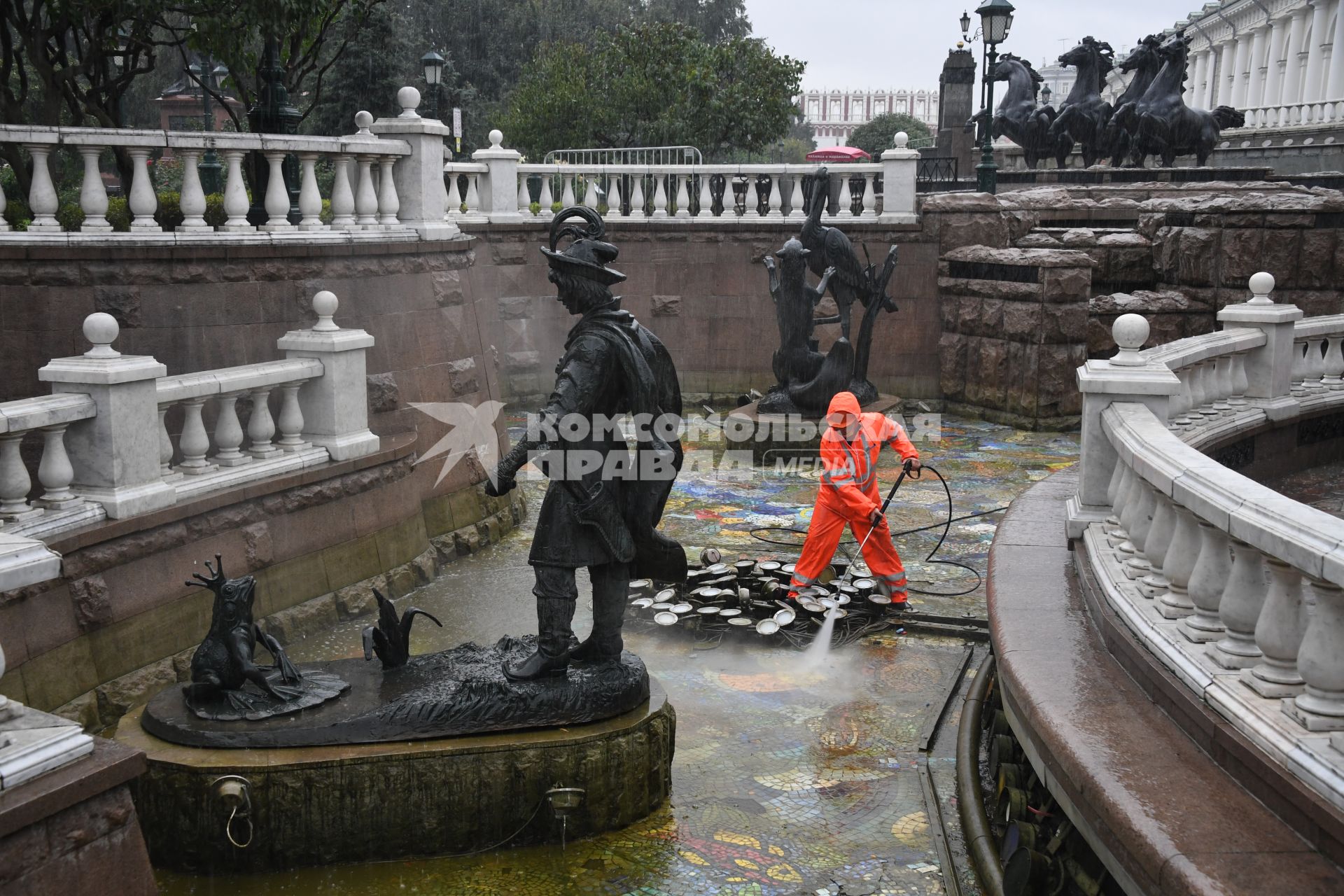Москва.  Сотрудник коммунальных служб моет фонтан `Иван царевич и царевна лягушка`на манежной площади.
