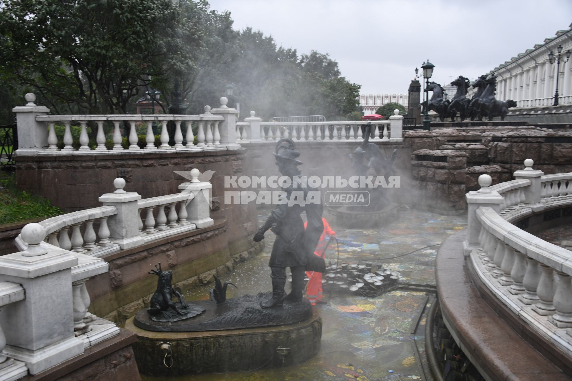 Москва.  Сотрудник коммунальных служб моет фонтан `Иван царевич и царевна лягушка`на манежной площади.