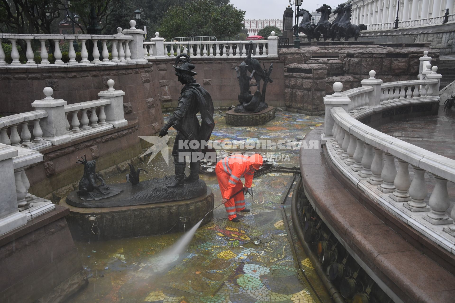 Москва.  Сотрудник коммунальных служб моет фонтан `Иван царевич и царевна лягушка`на манежной площади.