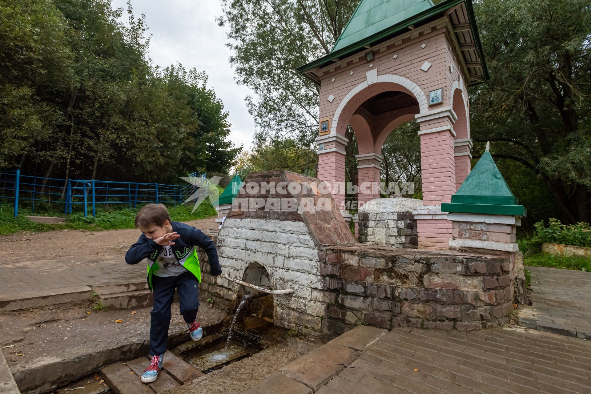 Москва. Мальчик пьет воду из источника на экологической тропе `У истоков рек`на территории ландшафтного заказника Теплый Стан.