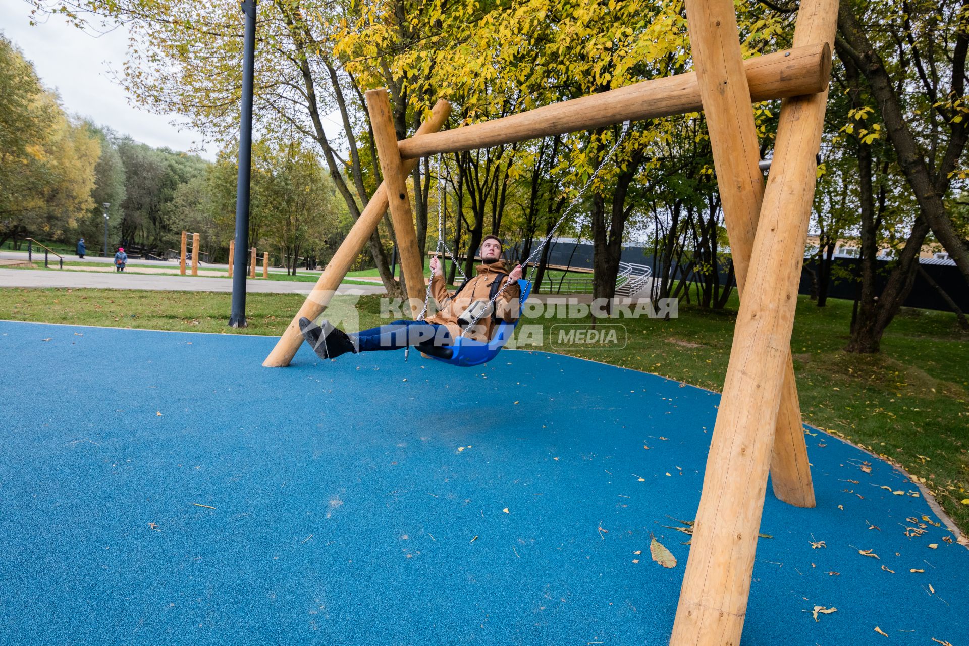 Москва. Корреспондент КП Андрей Абрамов качается на качелях из бревен в парке `Яуза.`