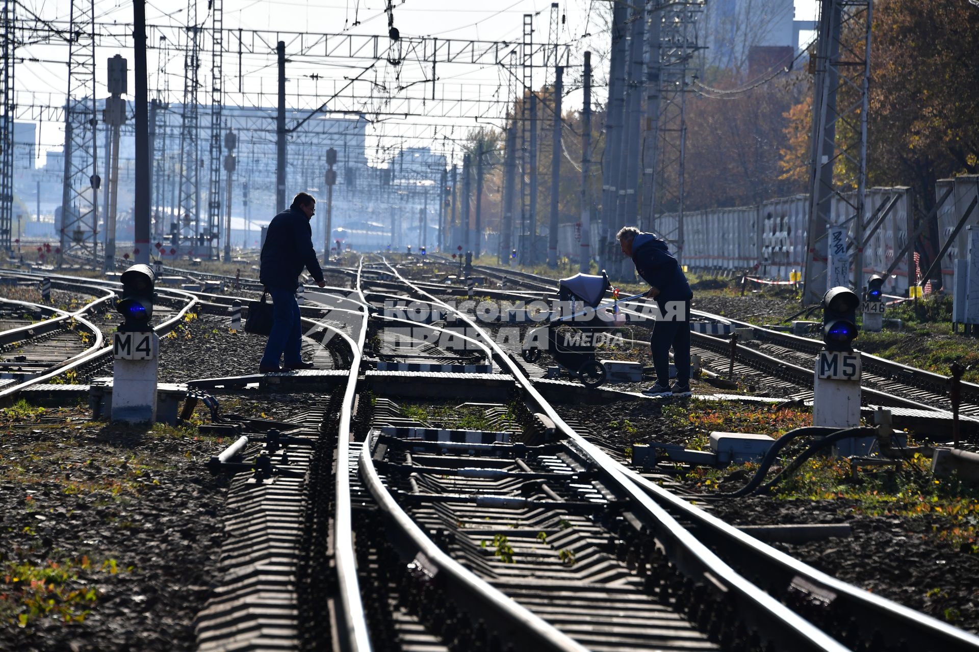 Москва.  Пешеходы на железнодорожном переезде.