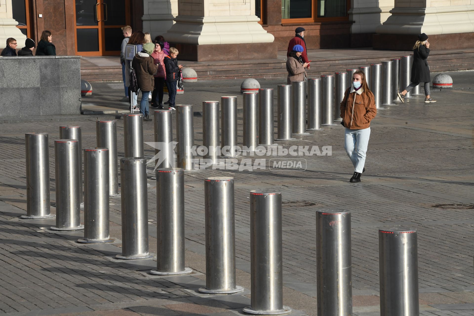 Москва.  Девушка в защитной маске на Манежной площади.