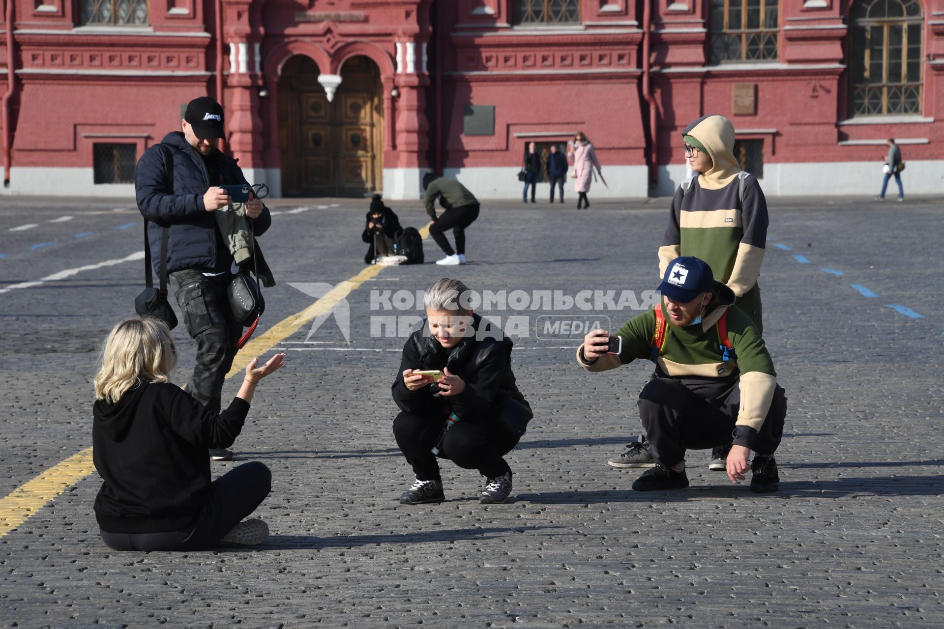 Москва.  Молодые люди фотографируются на Красной площади.