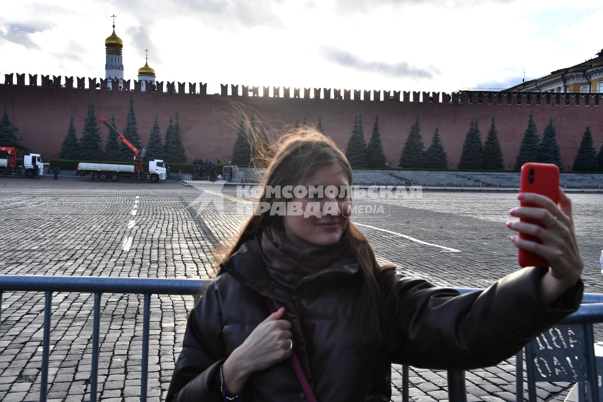 Москва. Девушка фотографирует на Красной площади, перекрытой в связи с обрушением зубцов на стене Московского Кремля из-за сильного ветра.