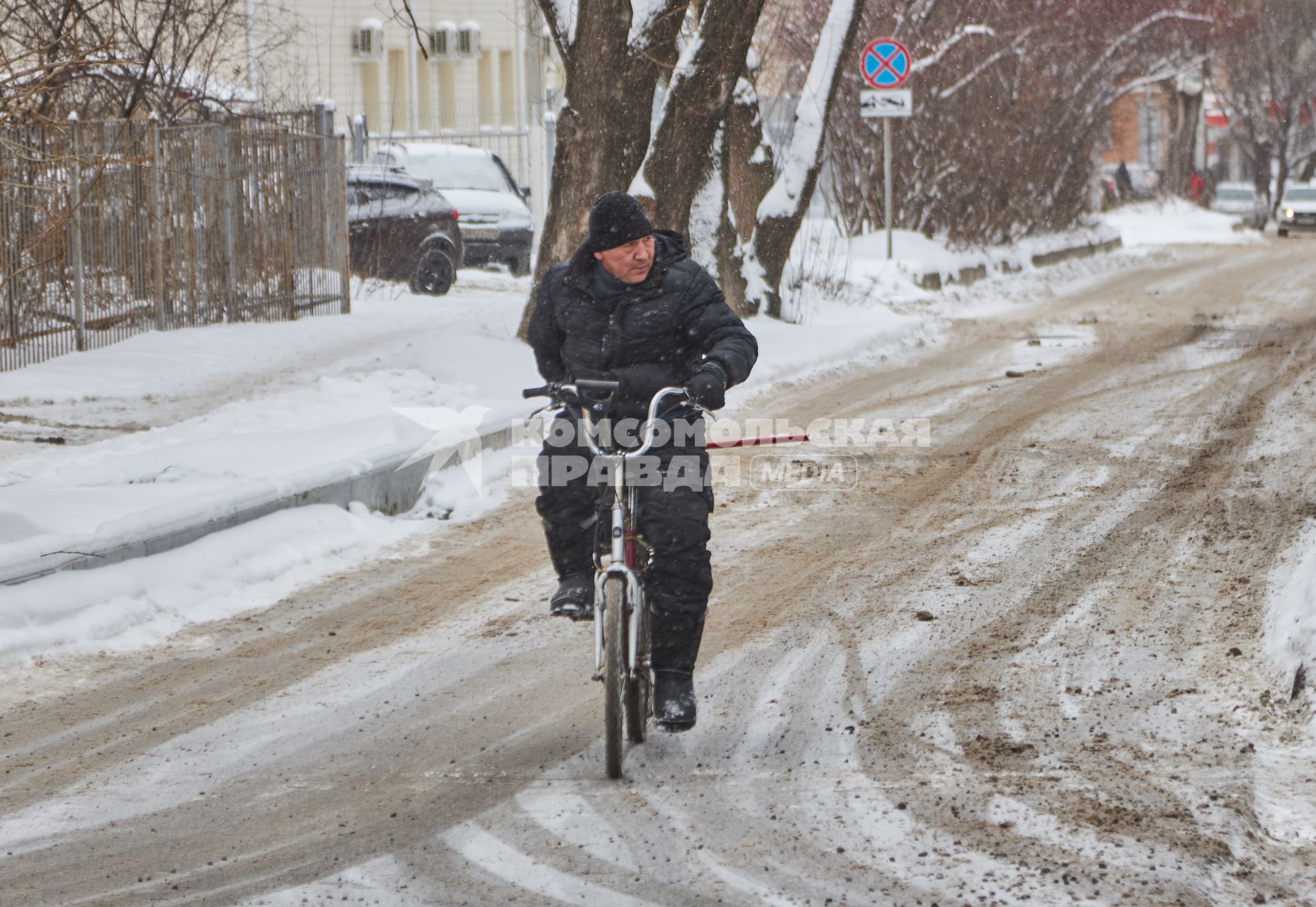 Пермь. Мужчина  на велосипеде  на заснеженной улице.