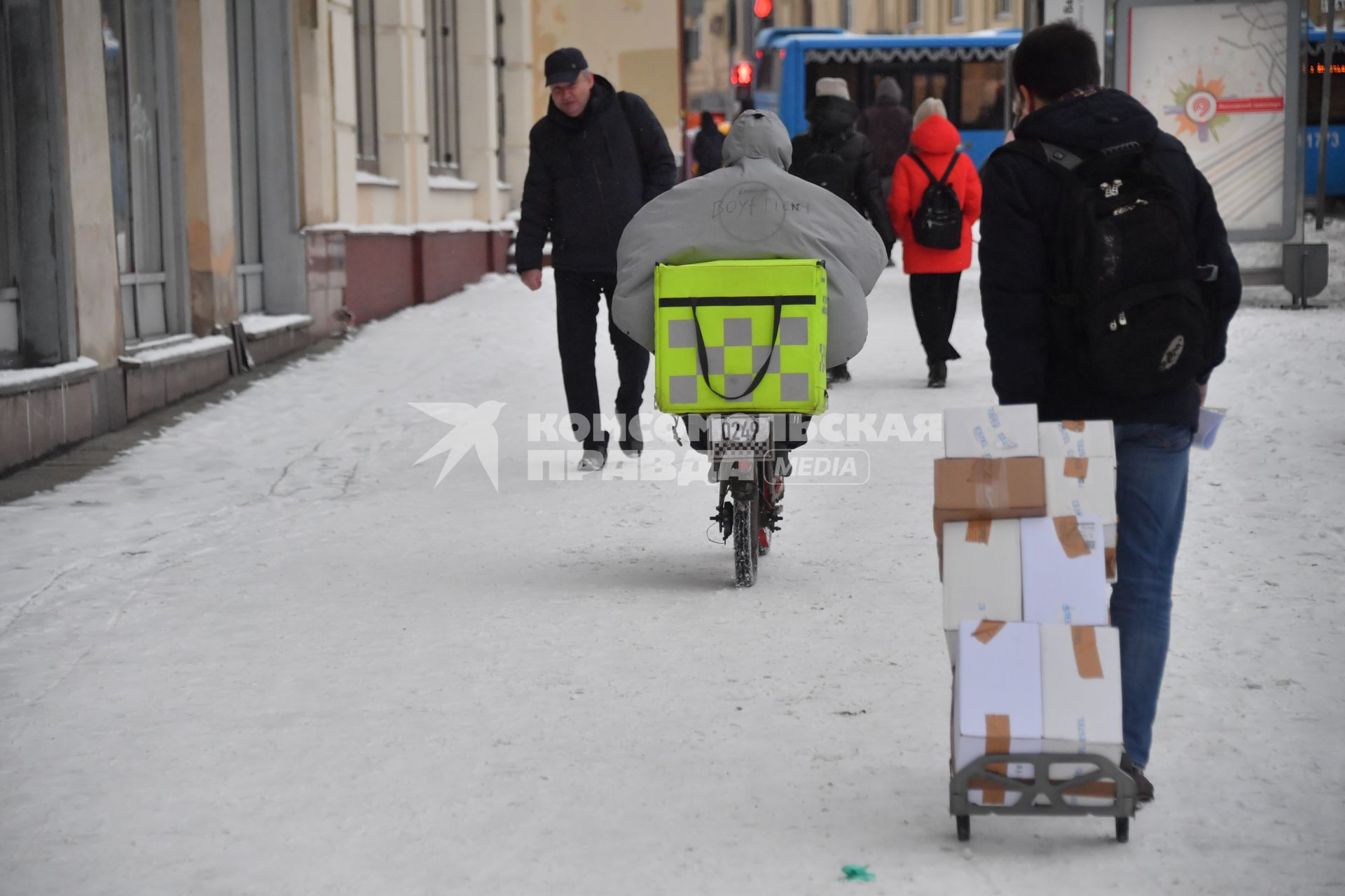 Москва. Сотрудник службы доставки на улице города.