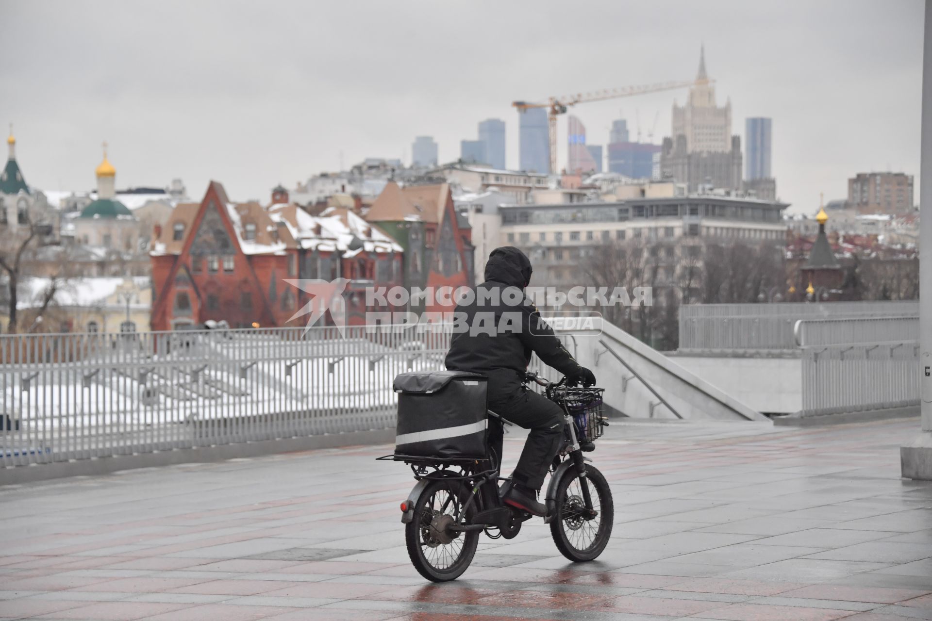 Москва. Сотрудник службы доставки на  мопеде.