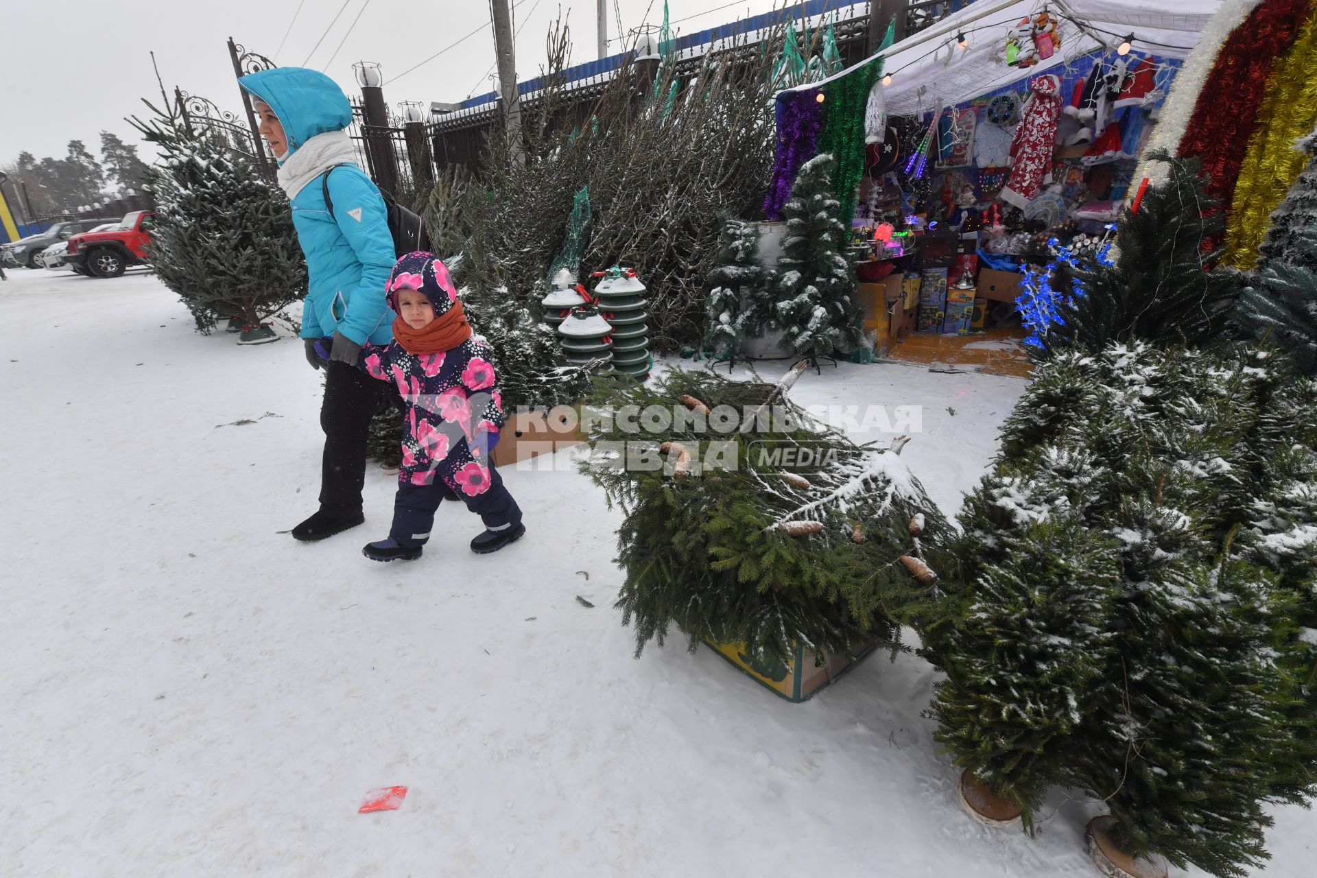 Москва. Женщина с ребенком на елочном базаре.