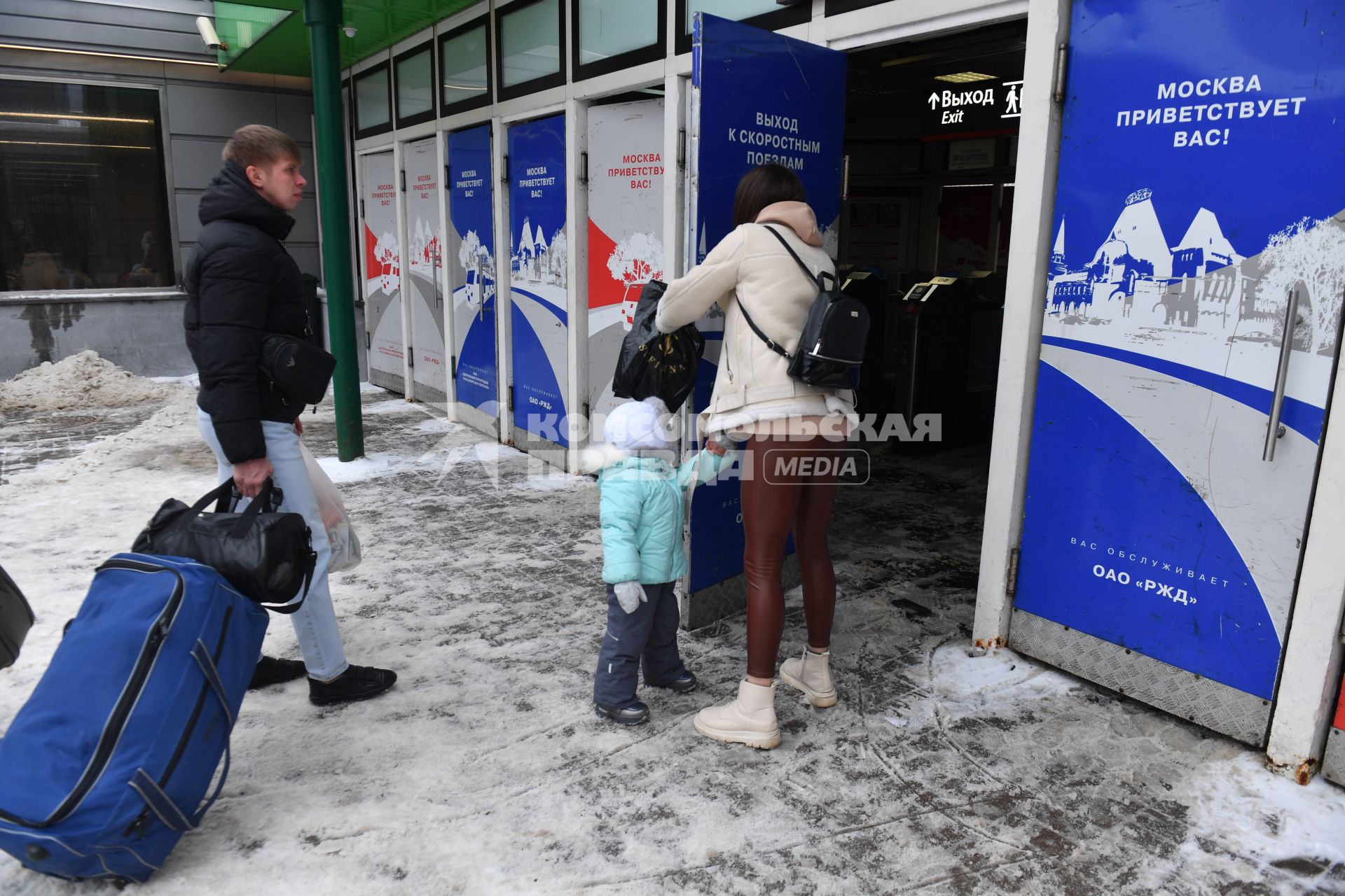 Москва. Пассажиры на Ярославском вокзале. Надпись на двери `Москва приветствует вас!`.