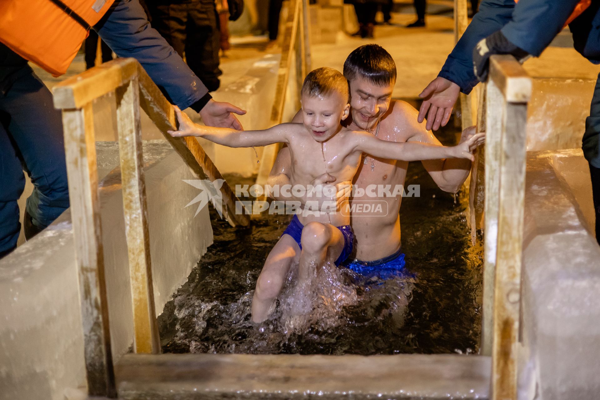 Челябинск. Мужчина с ребенком окунаются в купели во время ночных крещенских купаний.