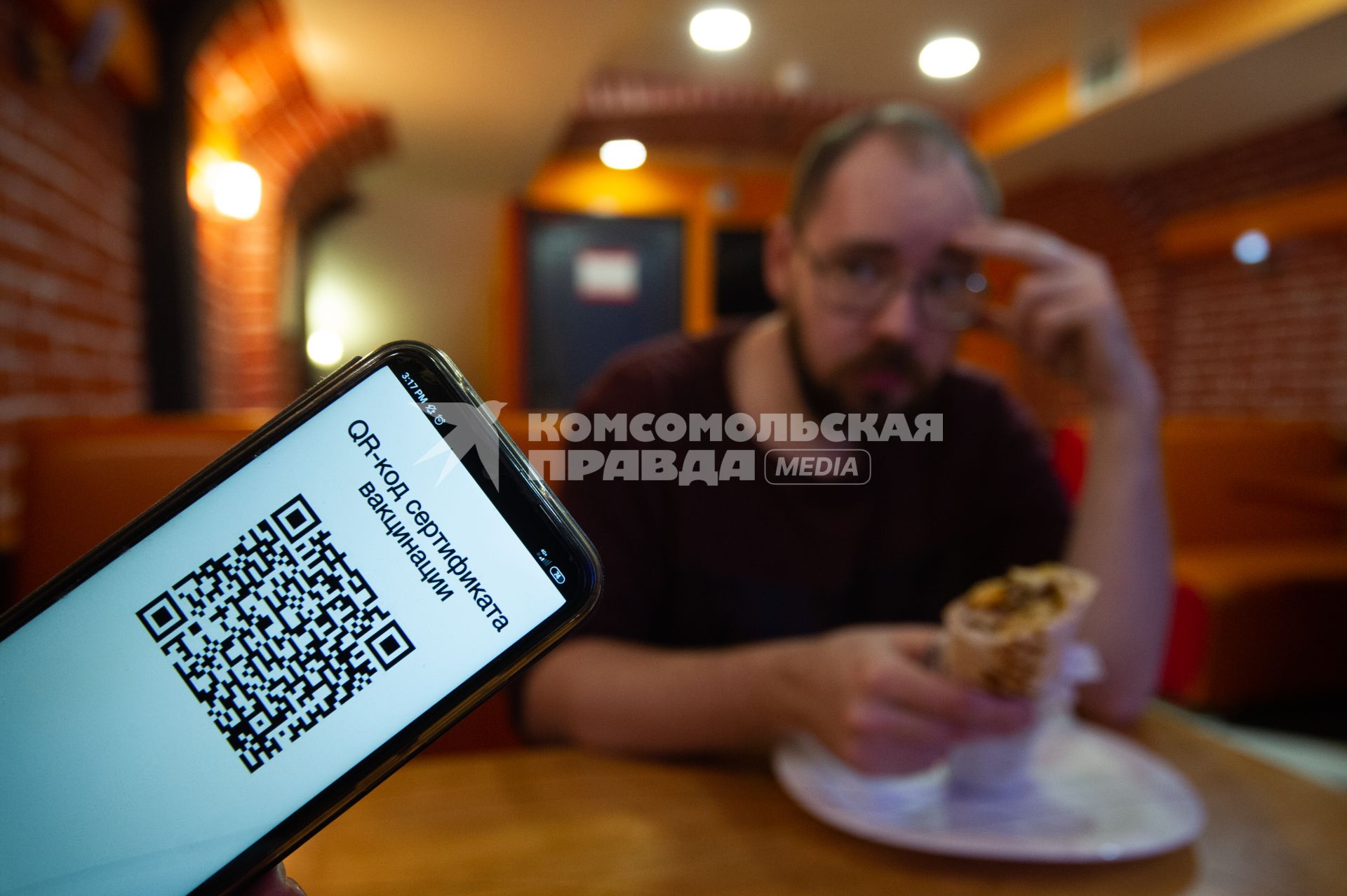 Санкт-Петербург. QR-код на экране мобильного телефона в кафе.