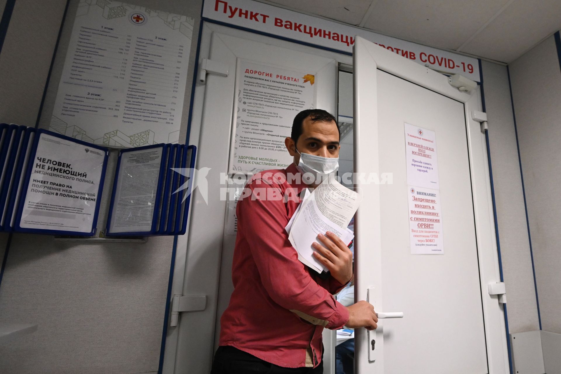 Санкт-Петербург. Мужчина выходит с медицинской картой из пункта вакцинации от коронавирусной инфекции в поликлинике.