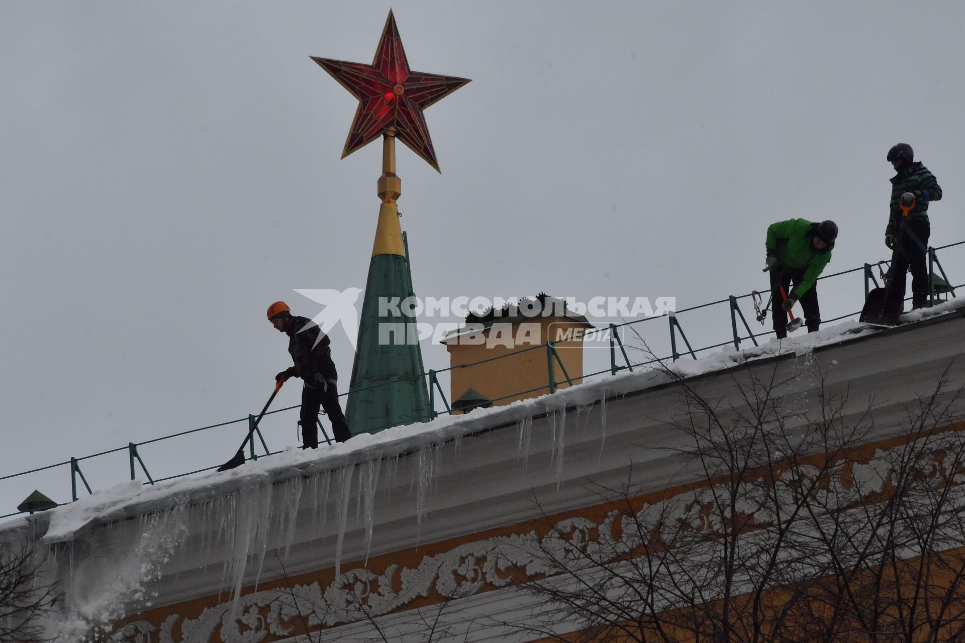 Москва. Сотрудники коммунальной службы чистят крышу здания Арсенала Московского Кремля от снега.