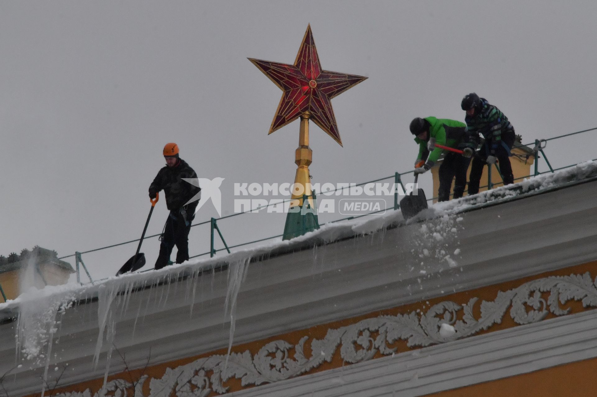 Москва. Сотрудники коммунальной службы чистят крышу здания Арсенала Московского Кремля от снега.