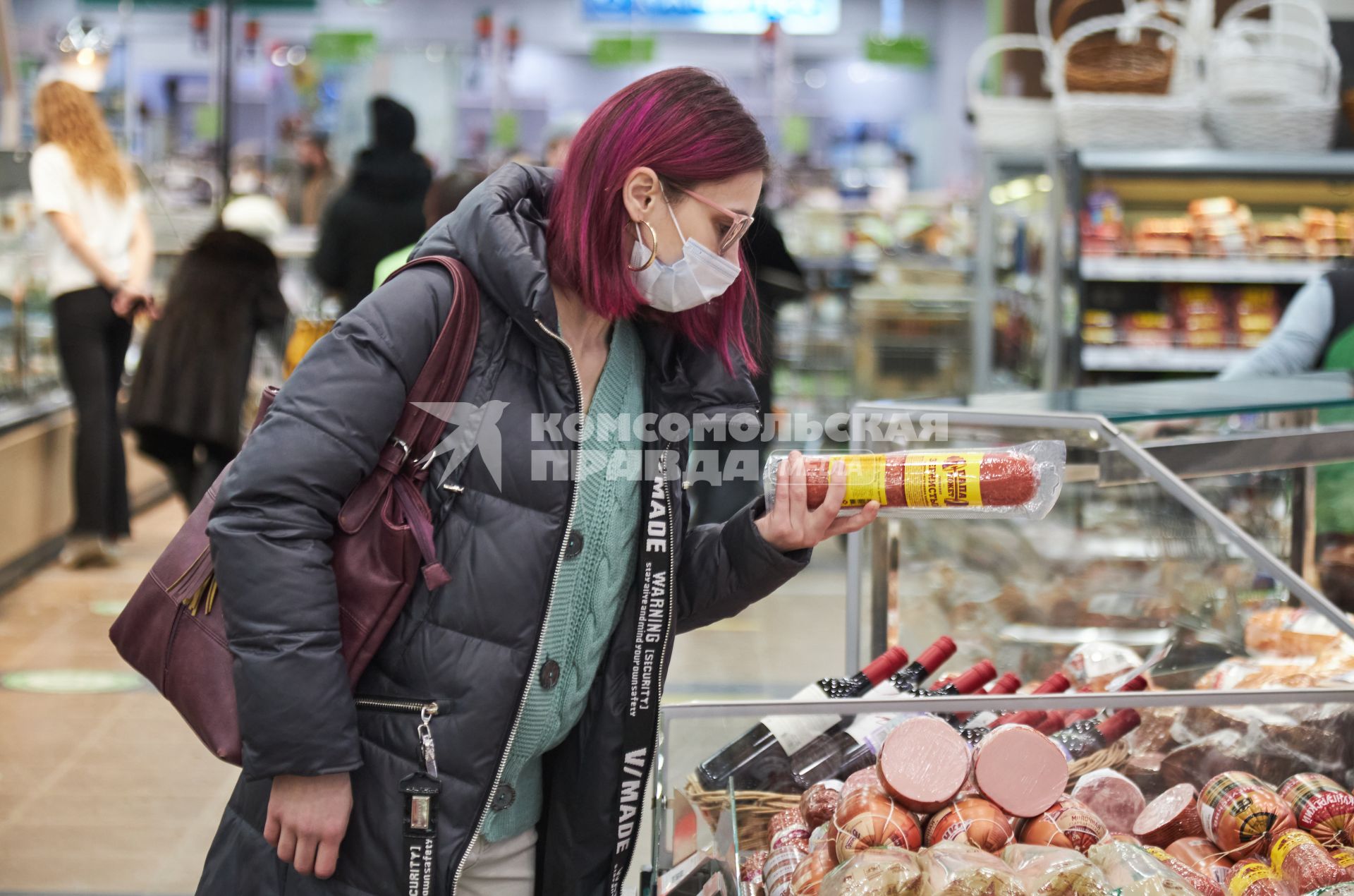 Пермь. Девушка выбирает колбасу в продуктовом магазине.