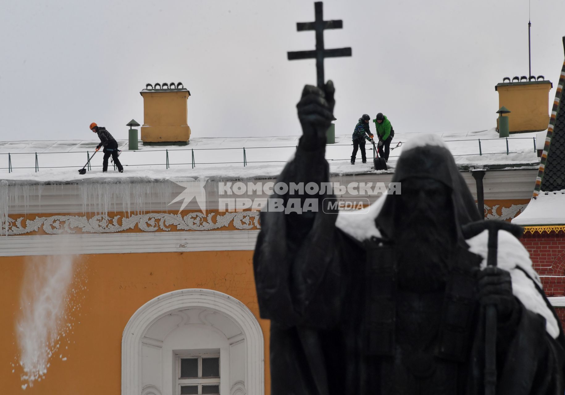 Москва.  Сотрудники  коммунальной службы чистят от снега крышу здания  Московского Кремля.