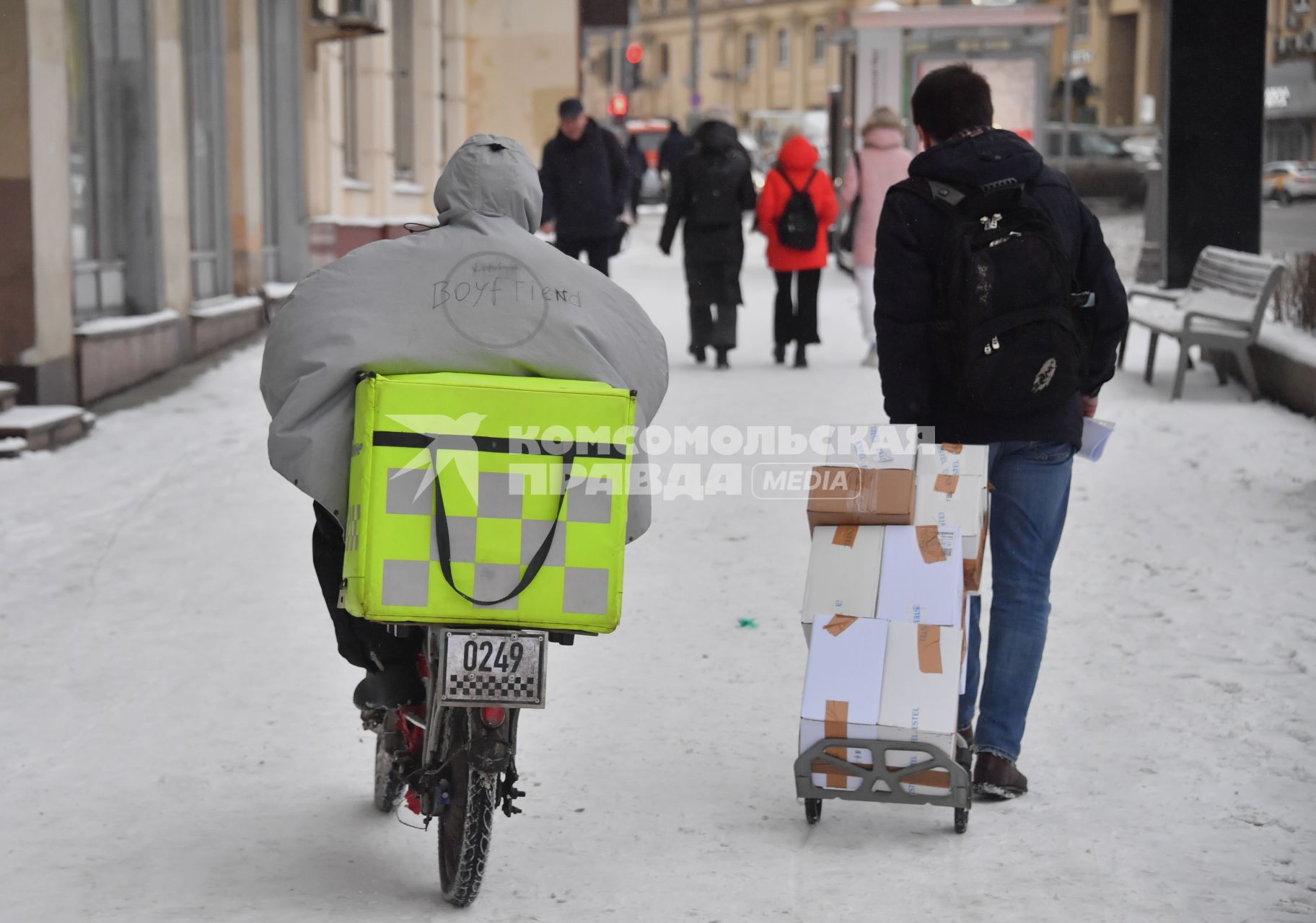 Москва.   Сотрудники службы доставки на улице города.