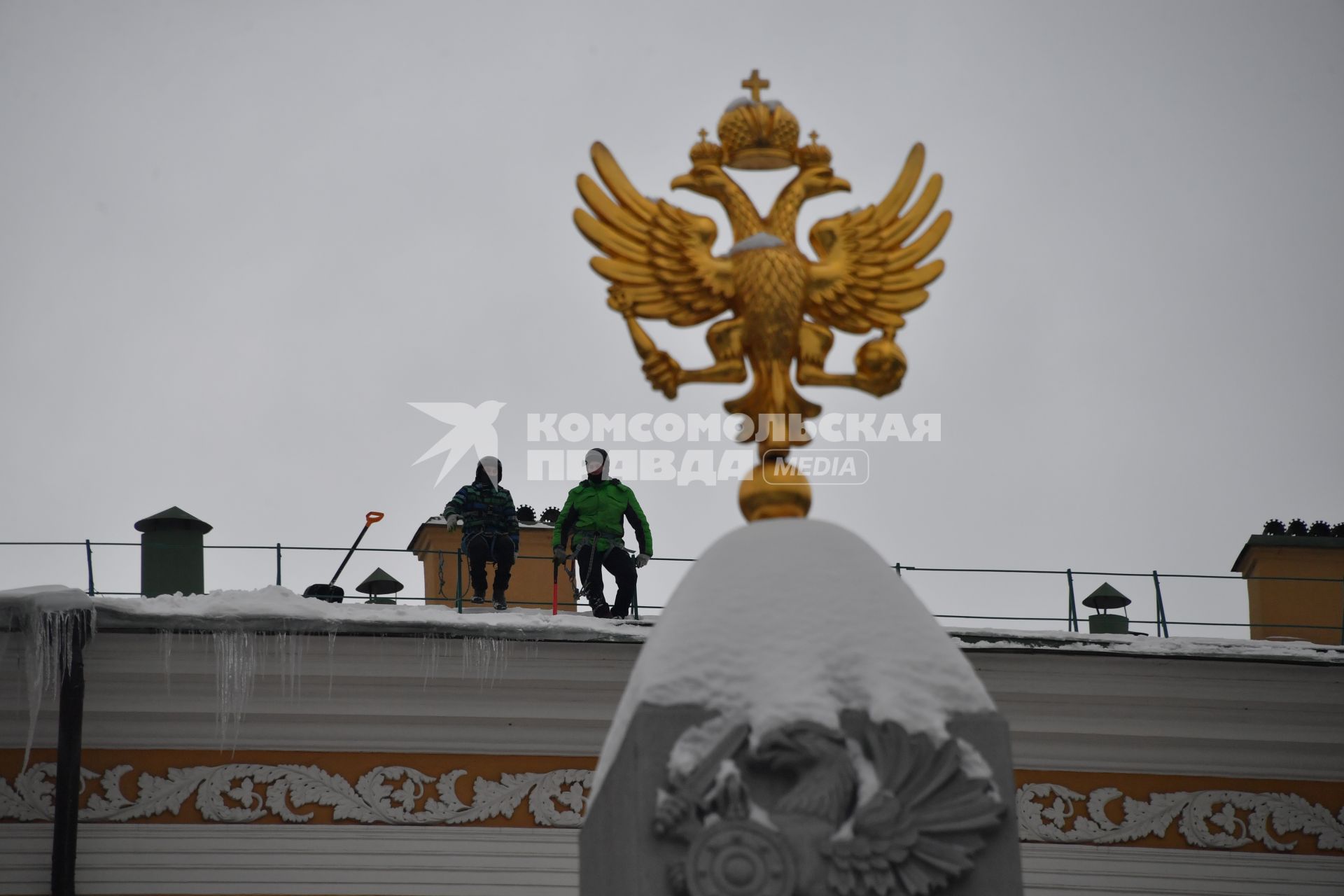 Москва.  Сотрудники  коммунальной службы чистят от снега крышу здания Арсенала Московского Кремля.