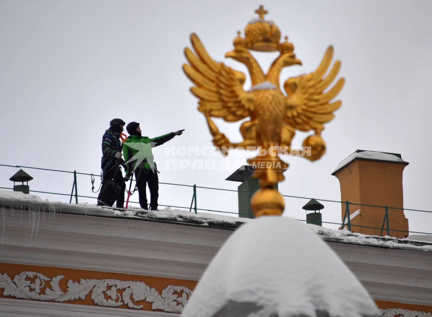 Москва.  Сотрудники  коммунальной службы чистят от снега крышу здания Арсенала Московского Кремля.