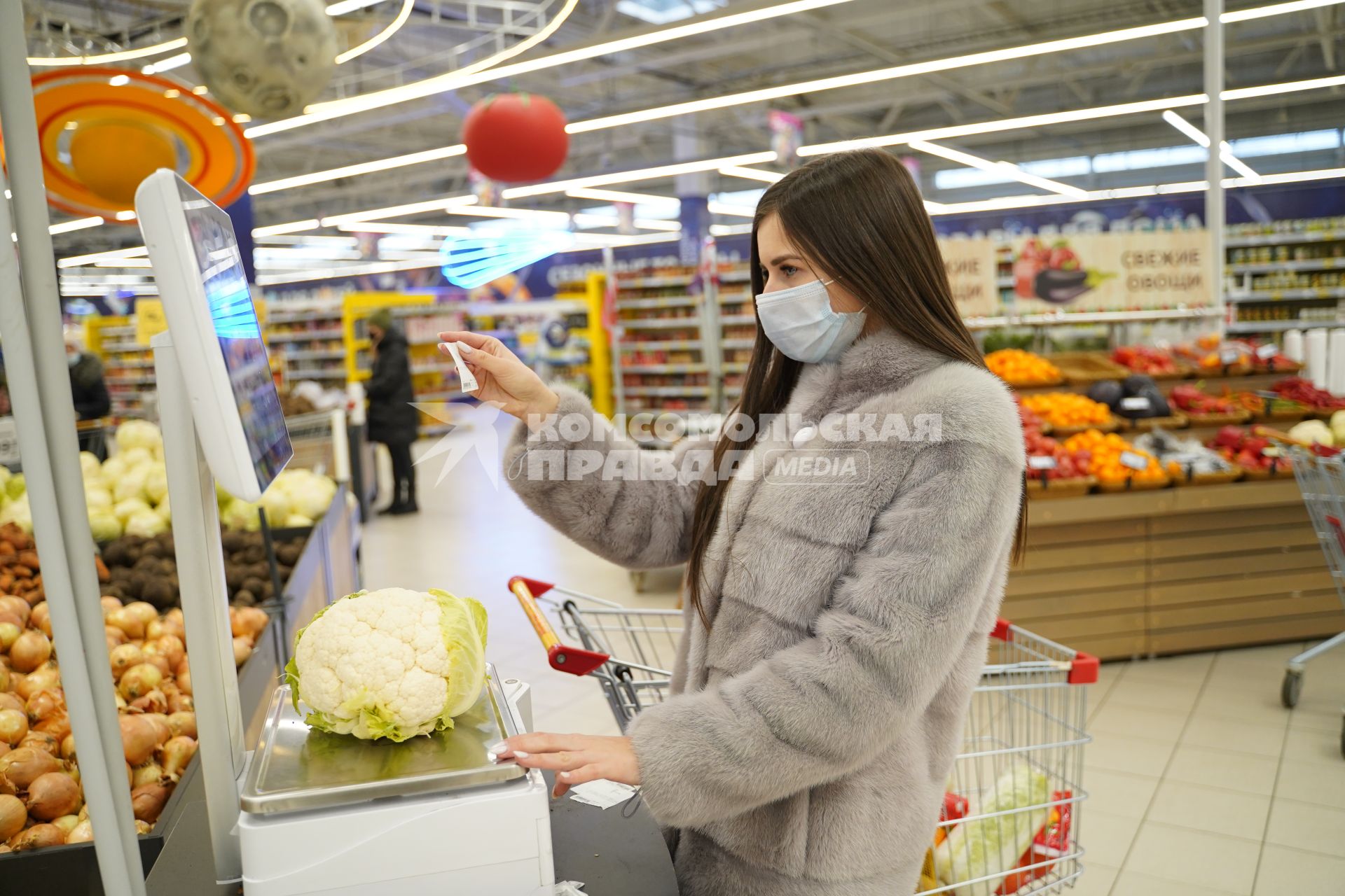 Самара. Девушка взвешивает цветную капусту в продуктовом магазине.