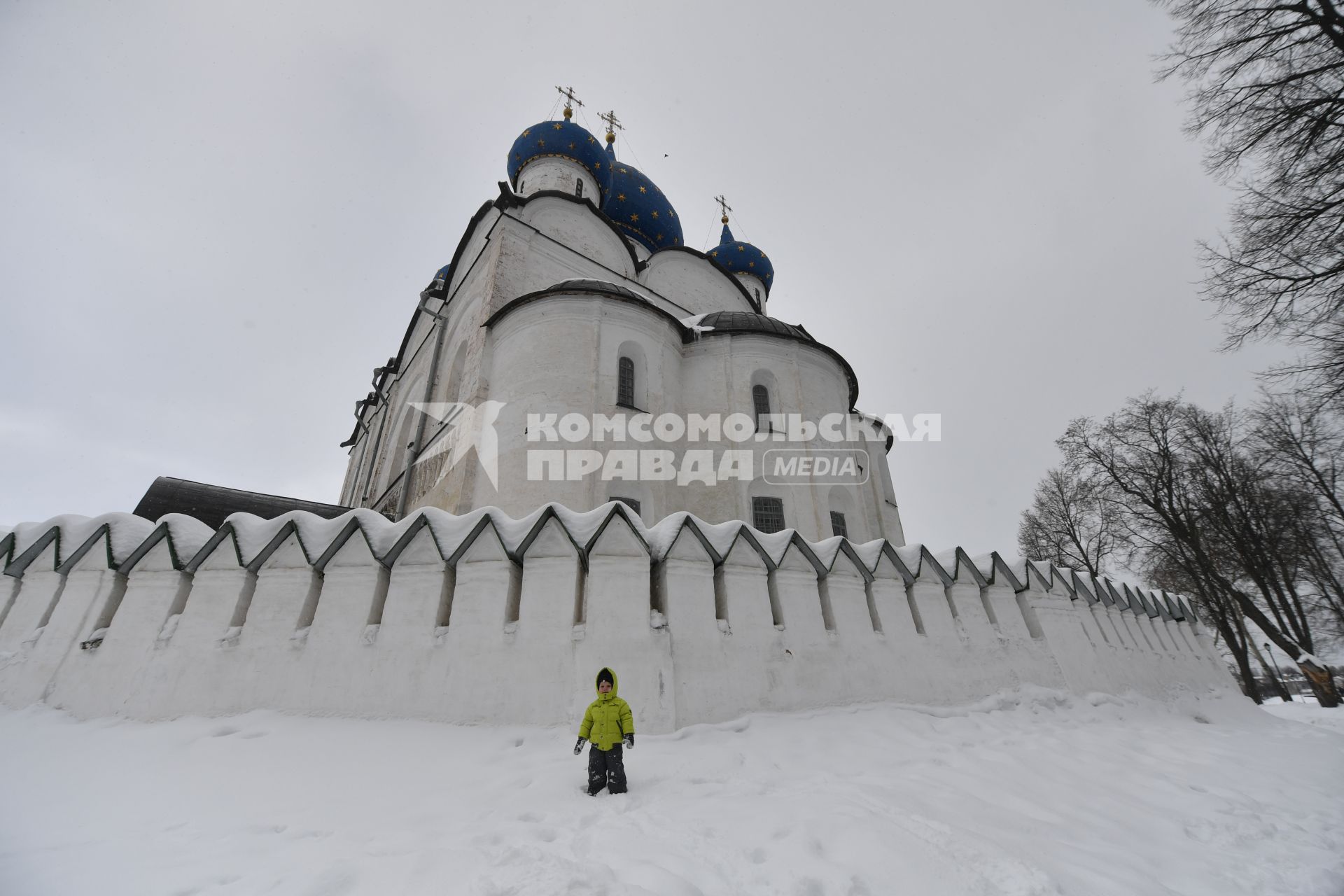 Суздаль. Ребенок стоит у монастырской стены.