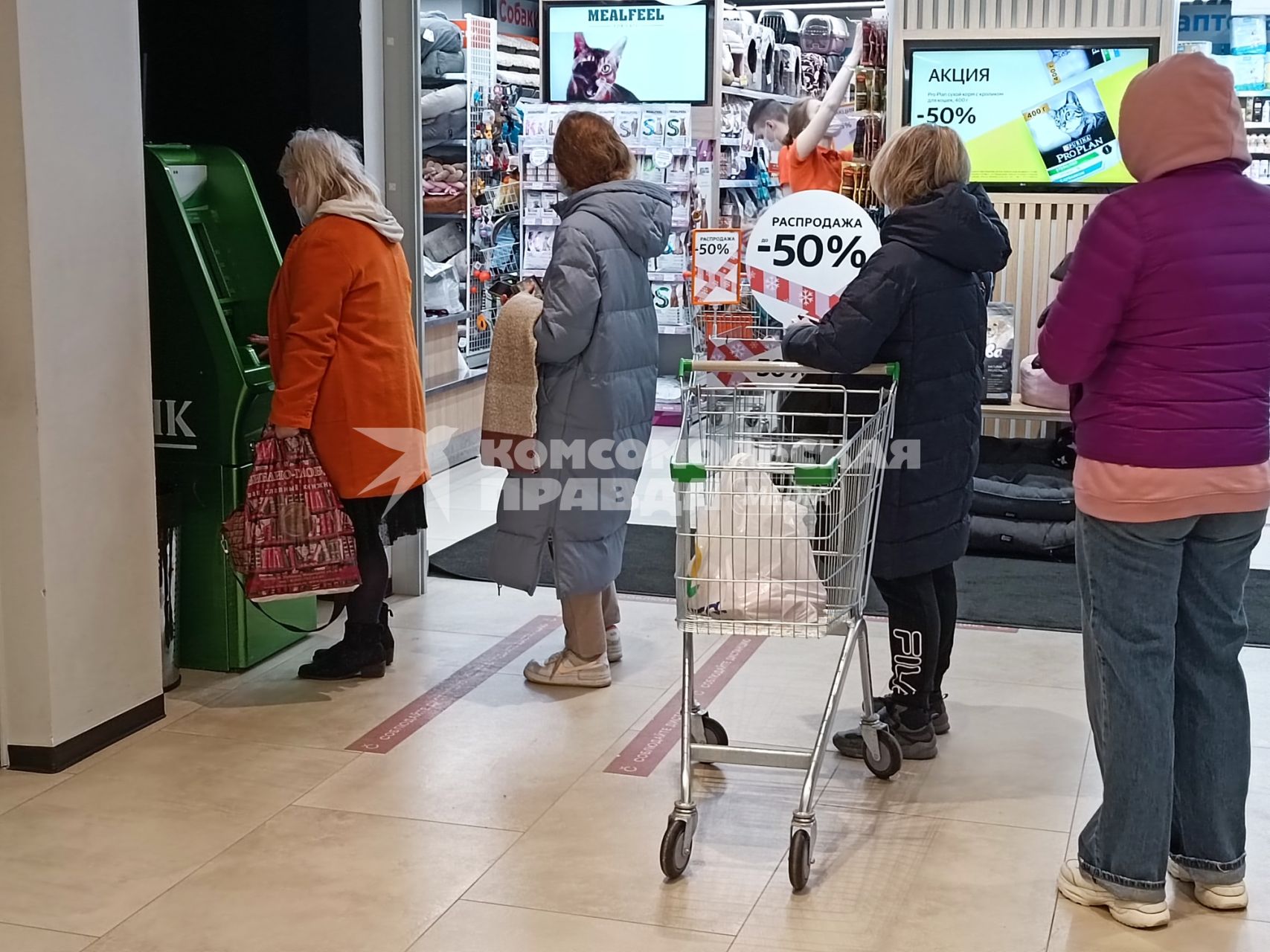 Москва.  Люди стоят в очереди к банкомату  в торговом центре.