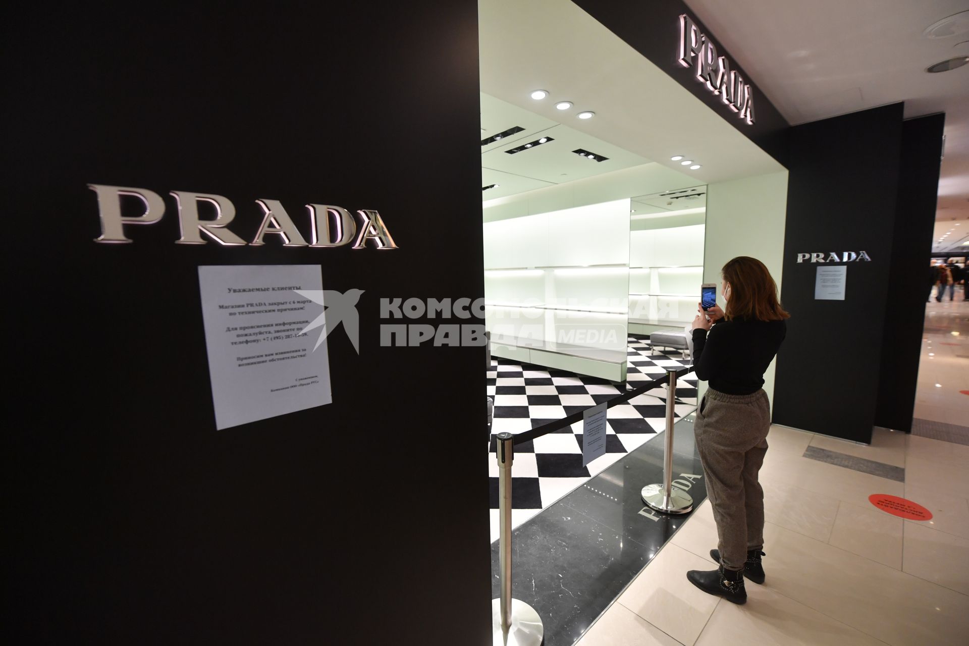 Москва. Девушка фотографирует на мобильный телефон бутик Prada в ЦУМе, закрытый с 6 марта по техническим причинам. Prada приостановил продажи в России из-за военной спецоперации РФ на Украине.