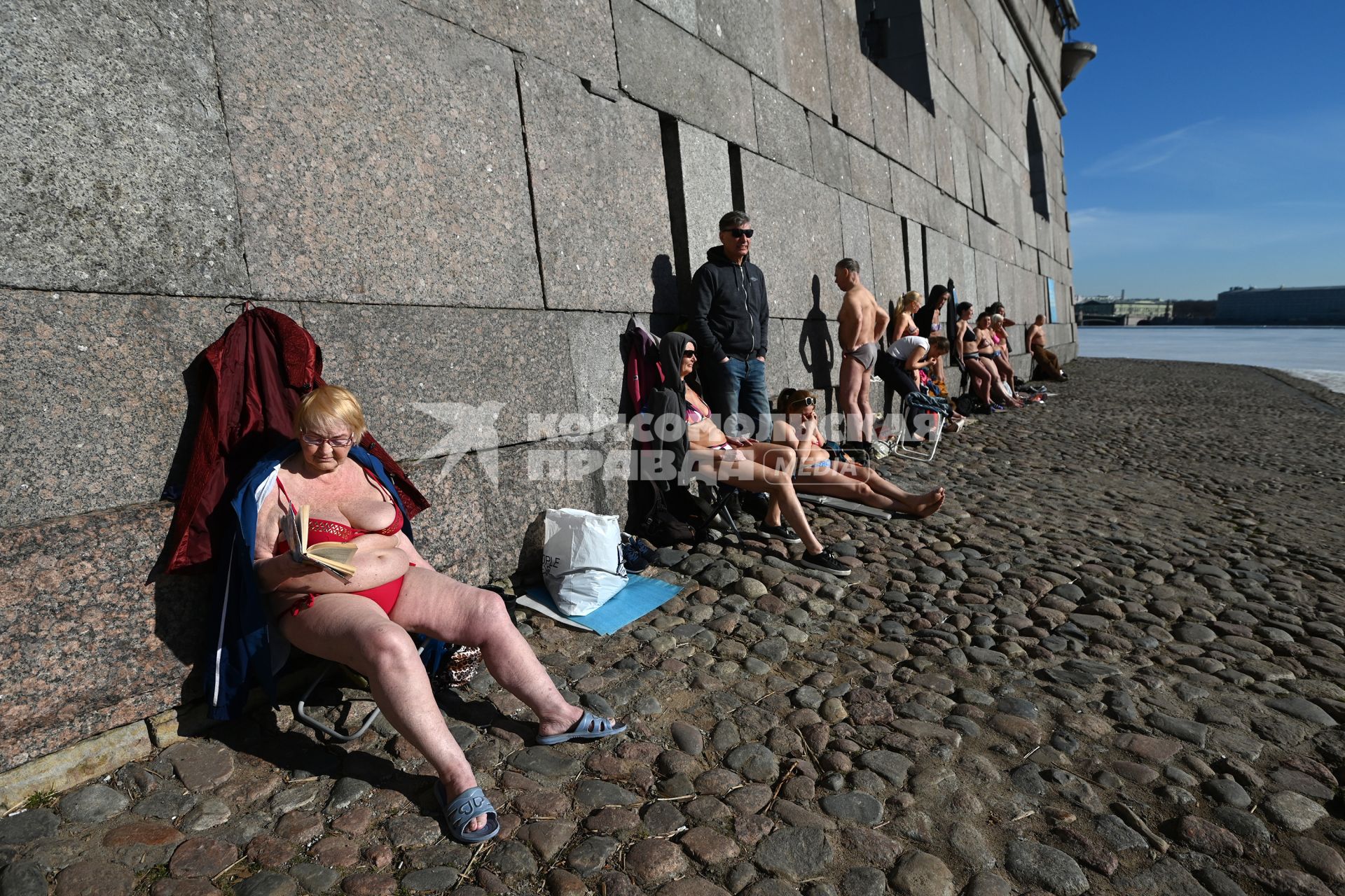 Санкт-Петербург. Люди загорают у стены Петропавловской крепости.