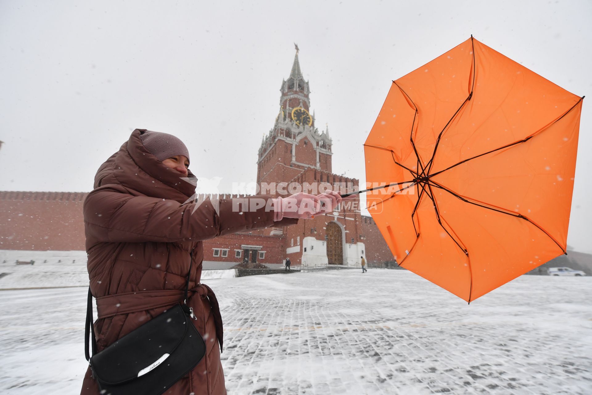 Москва. Девушка с зонтом во время сильного ветра на Красной площади.