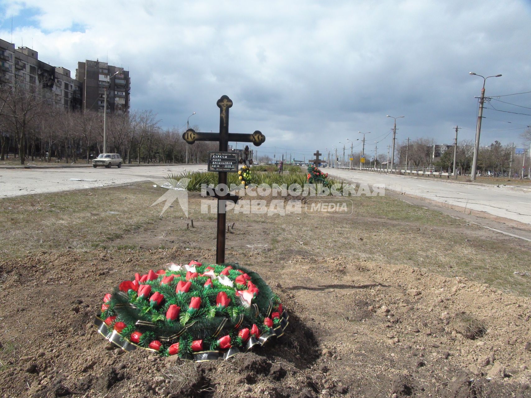 Украина. г.Мариуполь. Местные жители хоронят своих близких в городе. Могилы у дороги.