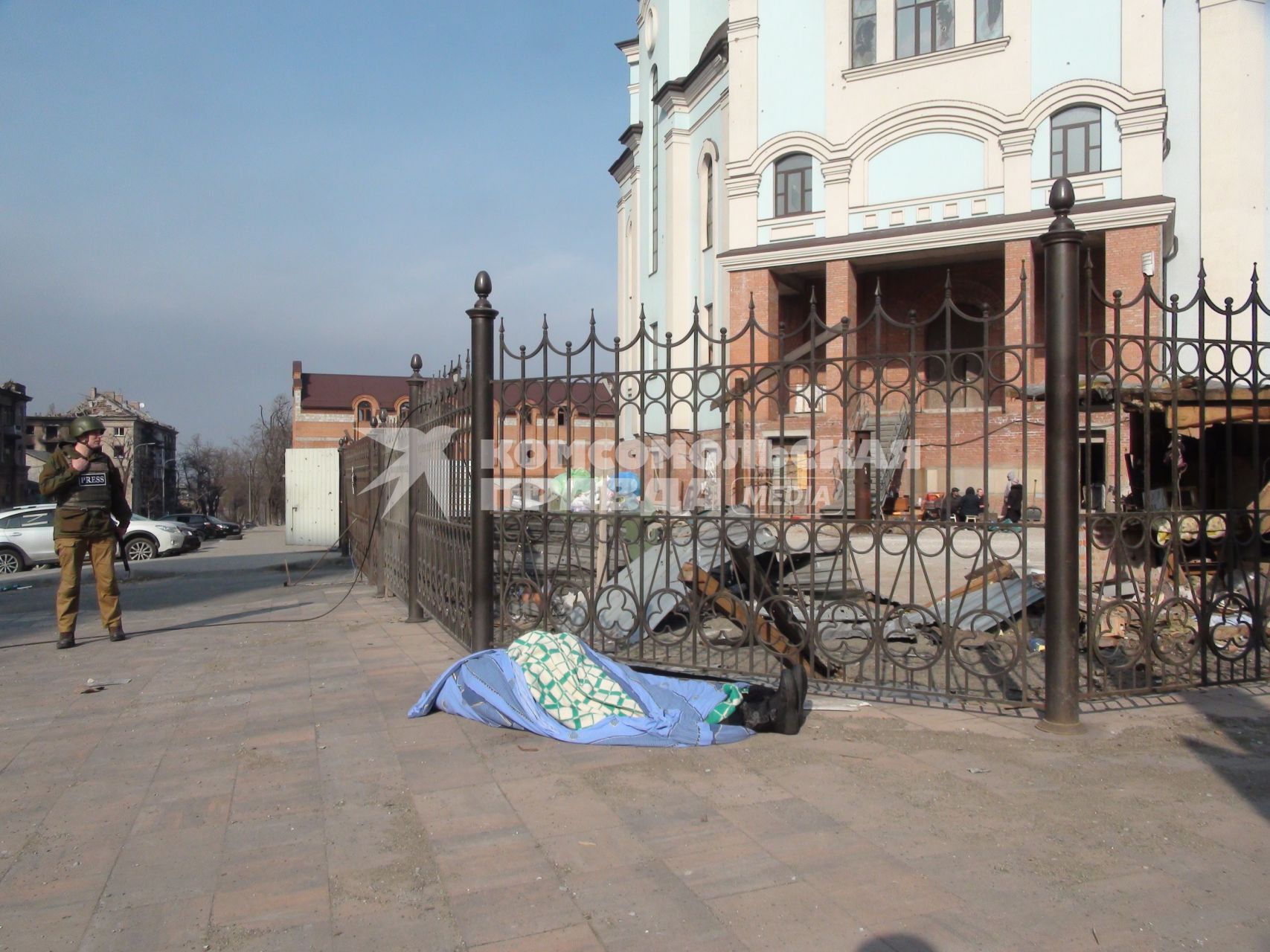 Украина. г.Мариуполь. У входа в храм лежит труп старушки, накрытый скатертью. Женщина ждала гуманитарку, а потом легла на асфальт и умерла.