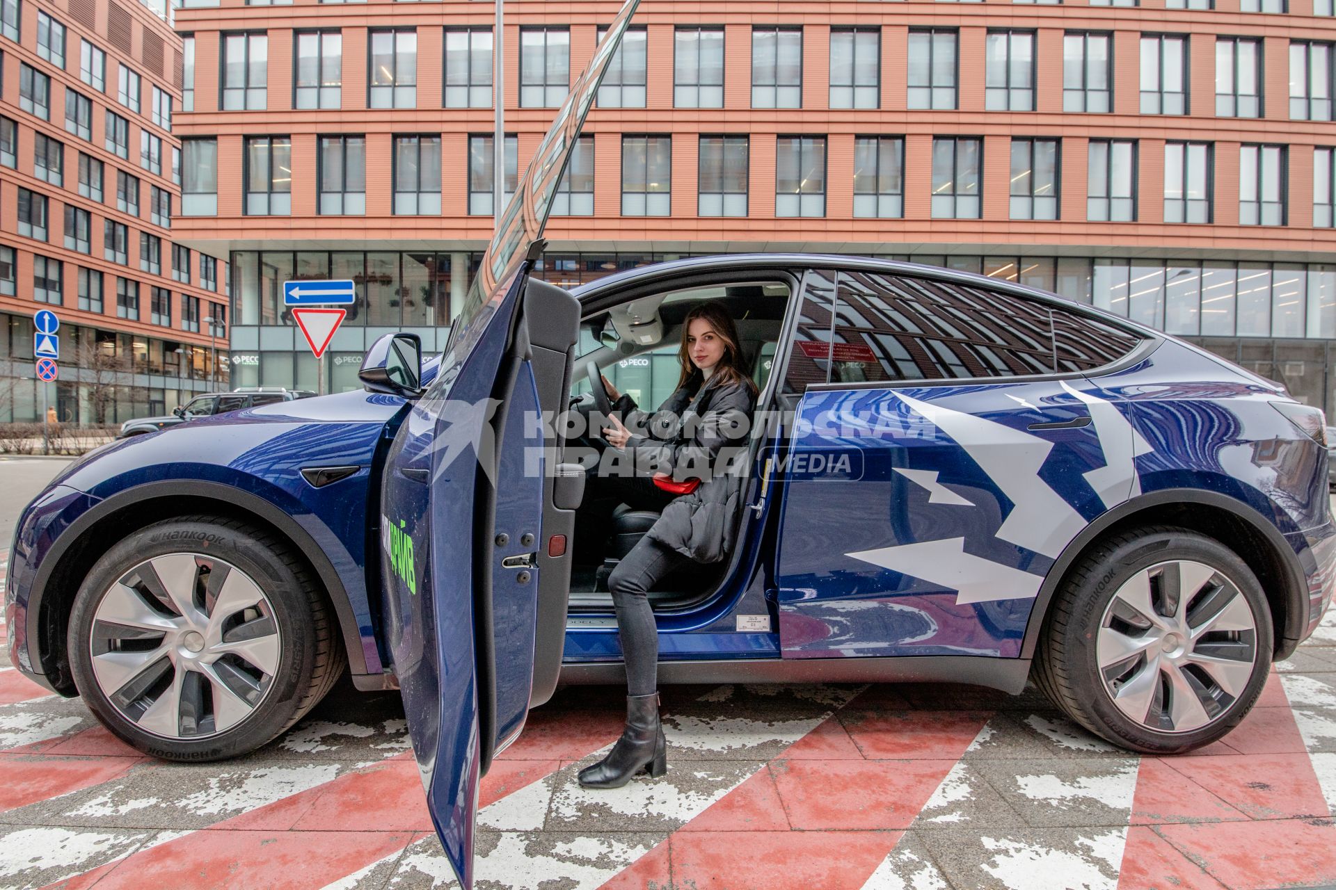 Москва. Девушка в электрокаре Tesla Model Y оператора каршеринга `Ситидрайв`.