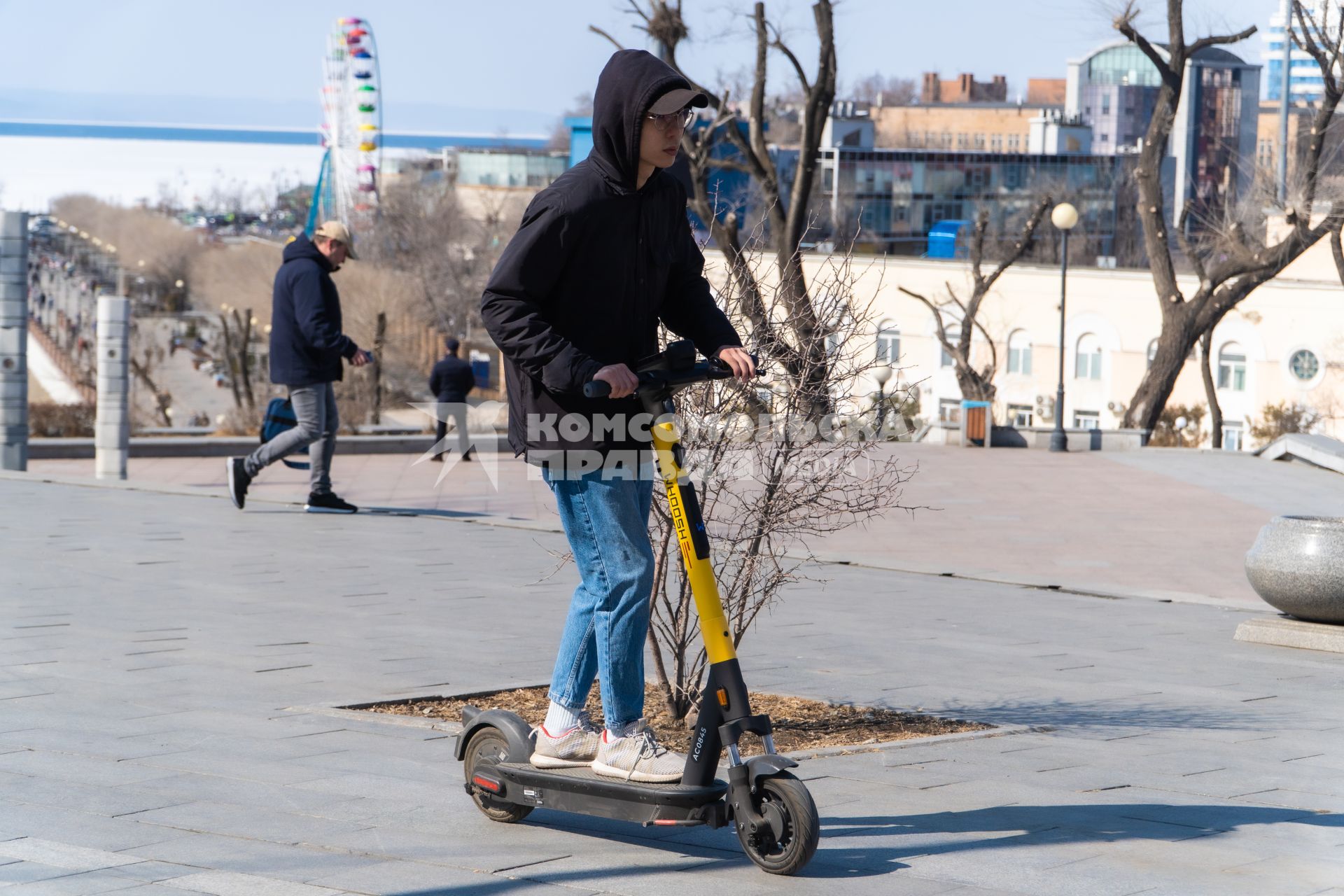 Владивосток. Молодой человек катается на электросамокате.