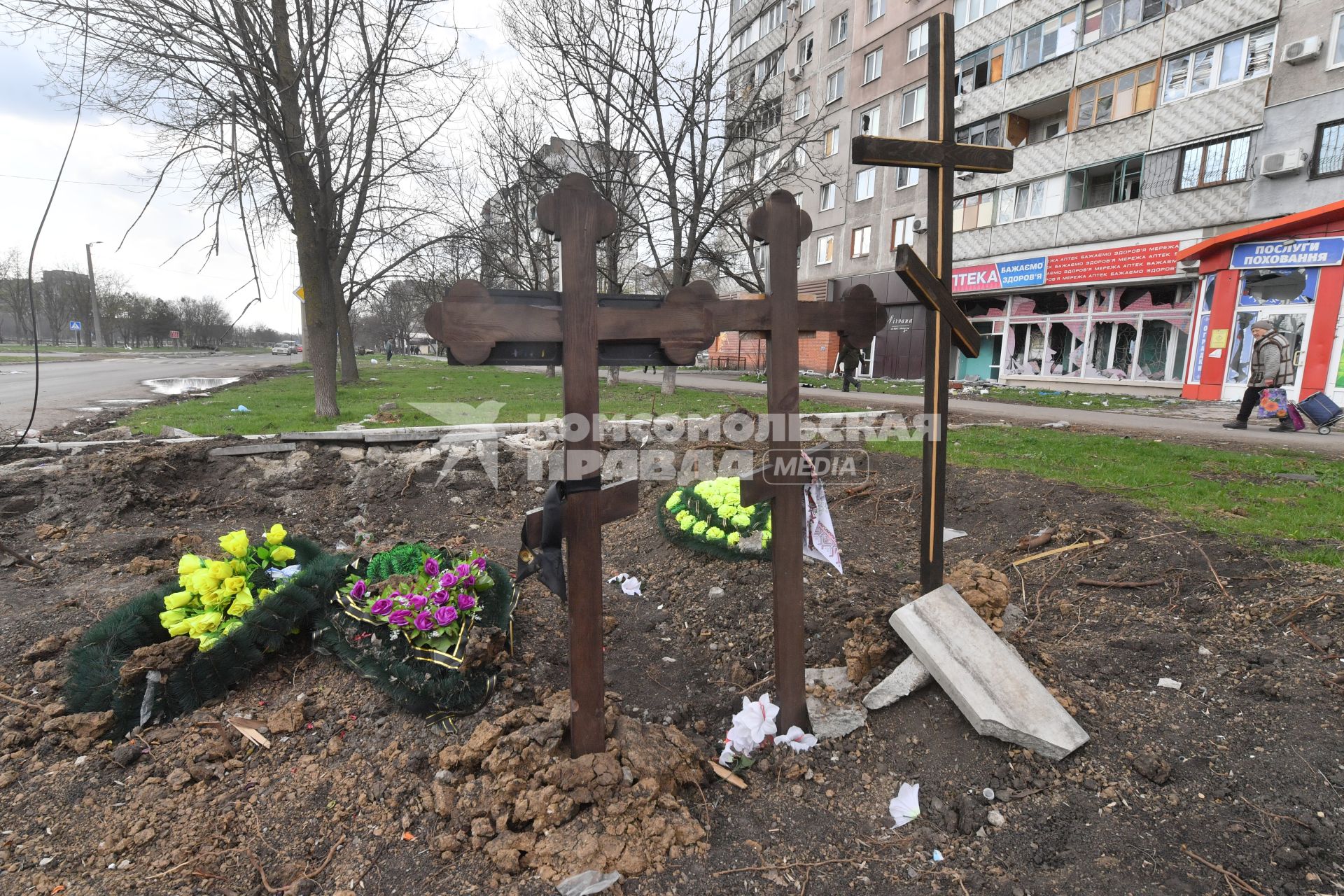 Украина. г.Мариуполь. Местные жители хоронят своих близких в городе. Могилы у дороги.