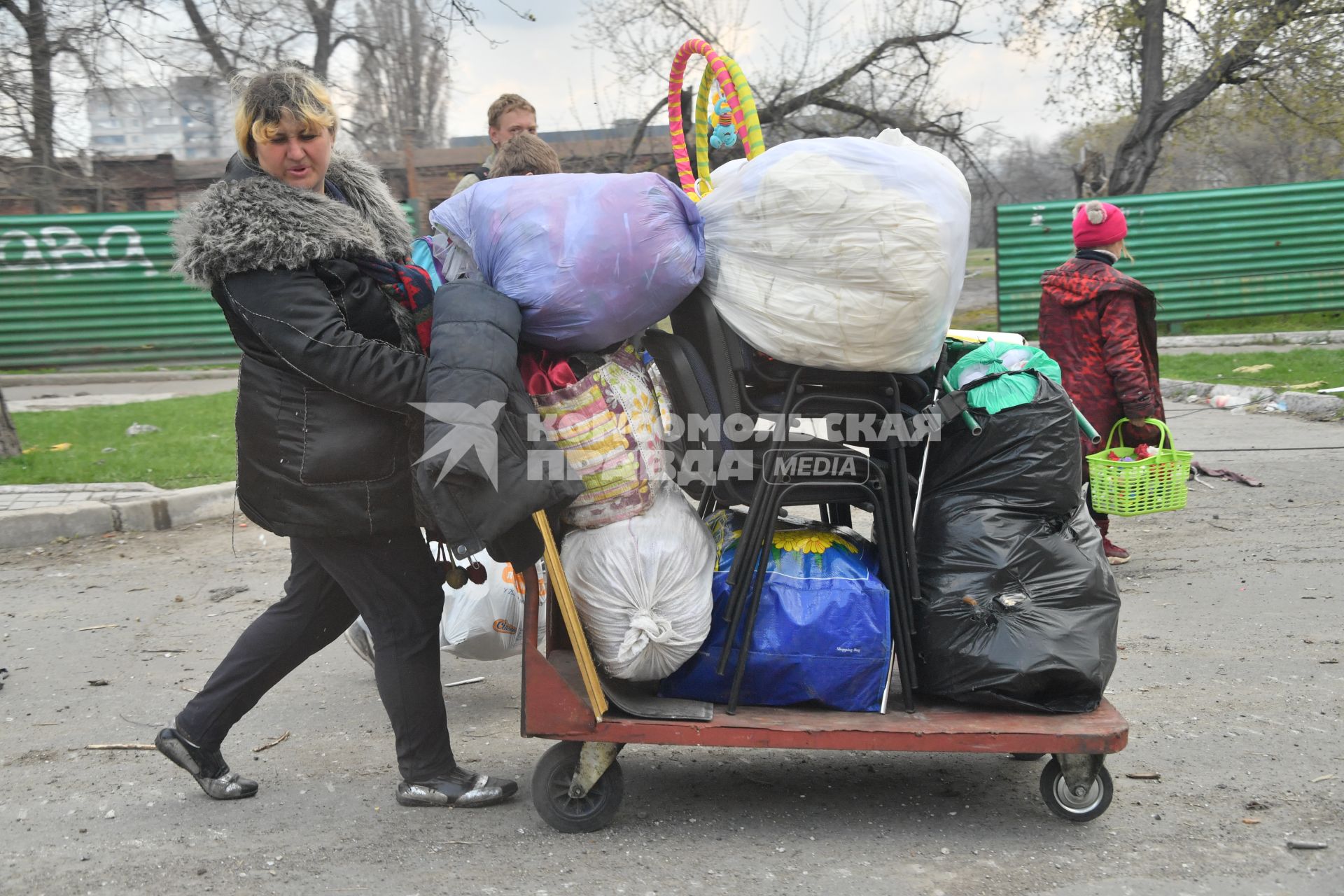 Украина. г.Мариуполь. Женщина везет на тележке вещи.