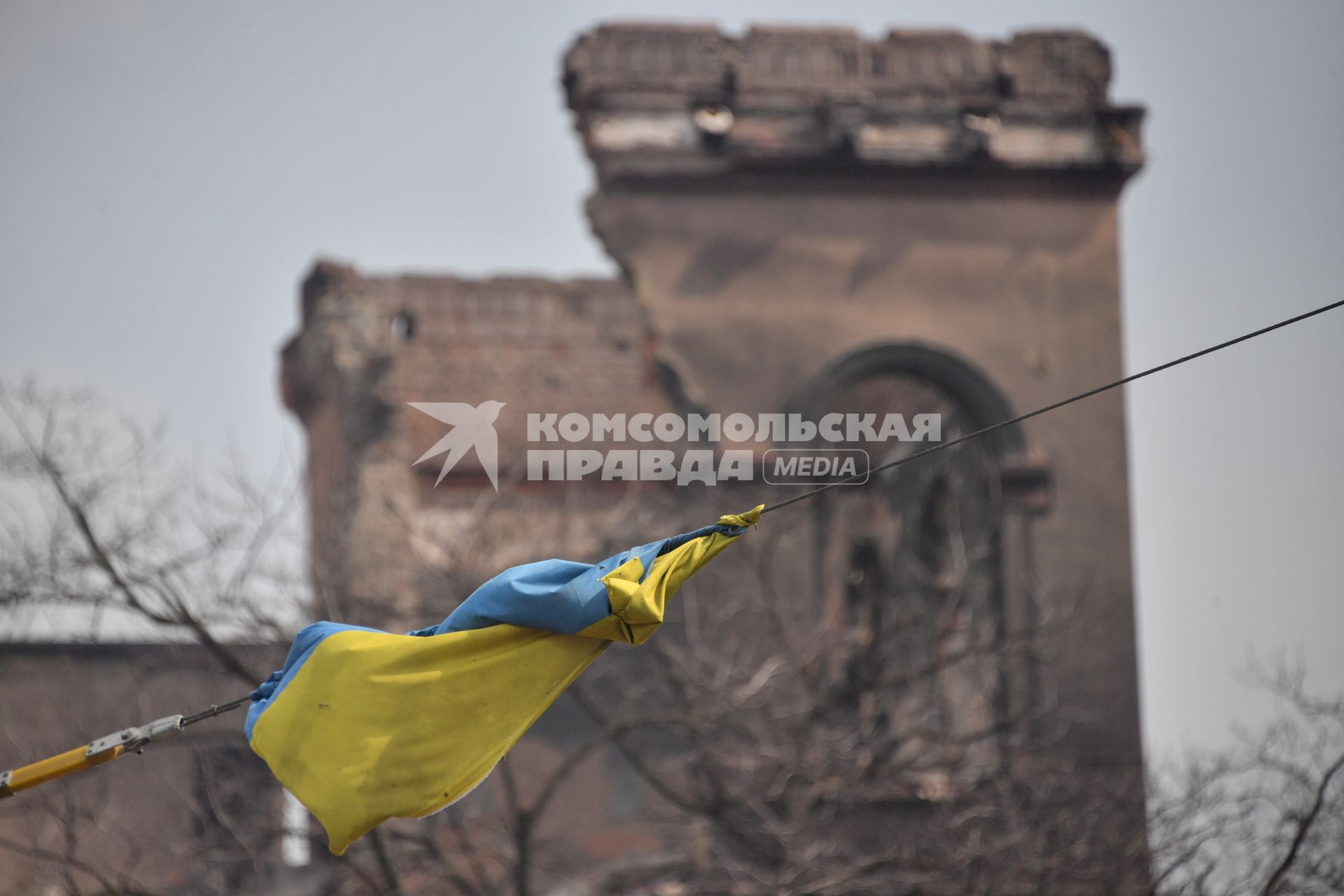 Украина. г.Мариуполь. Украинский флаг на фоне разрушенного здания.