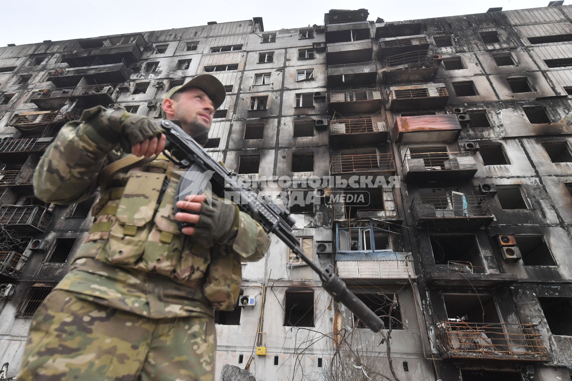 Украина. г.Мариуполь. Военнослужащий рядом с жилым домом, разрушенным в результате обстрелов.