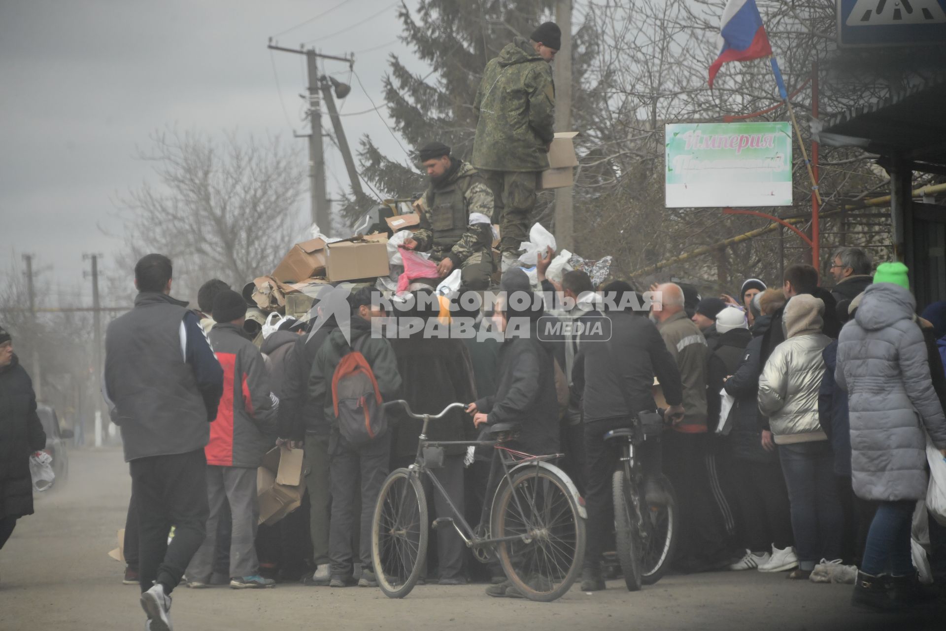 Украина. г.Мариуполь. Военнослужащие на бронетехнике раздают гуманитарную помощь местным жителям.