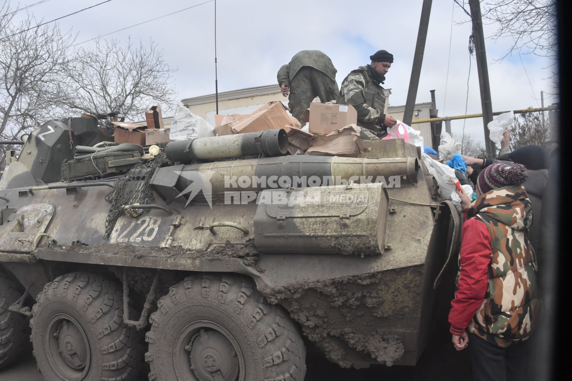 Украина. г.Мариуполь. Военнослужащие на бронетехнике раздают гуманитарную помощь местным жителям.