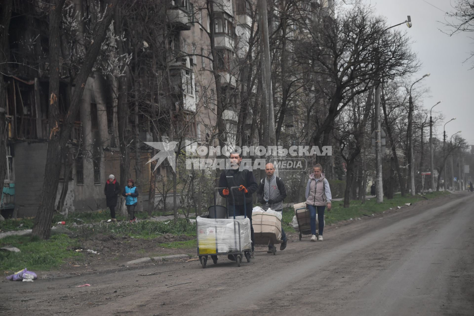 Донецкая область. г.Мариуполь. Жители города с вещами идут по улице.