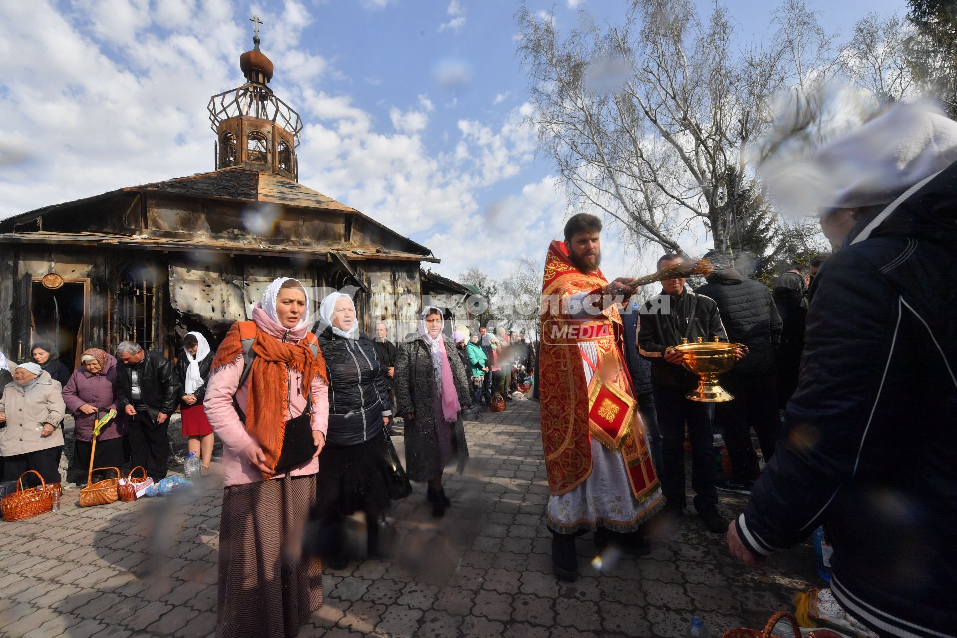 Волноваха, Донецкая народная республика. Верующие и священнослужитель во время освящения пасхальных яиц и куличей после пасхальной службы в Православном храме.