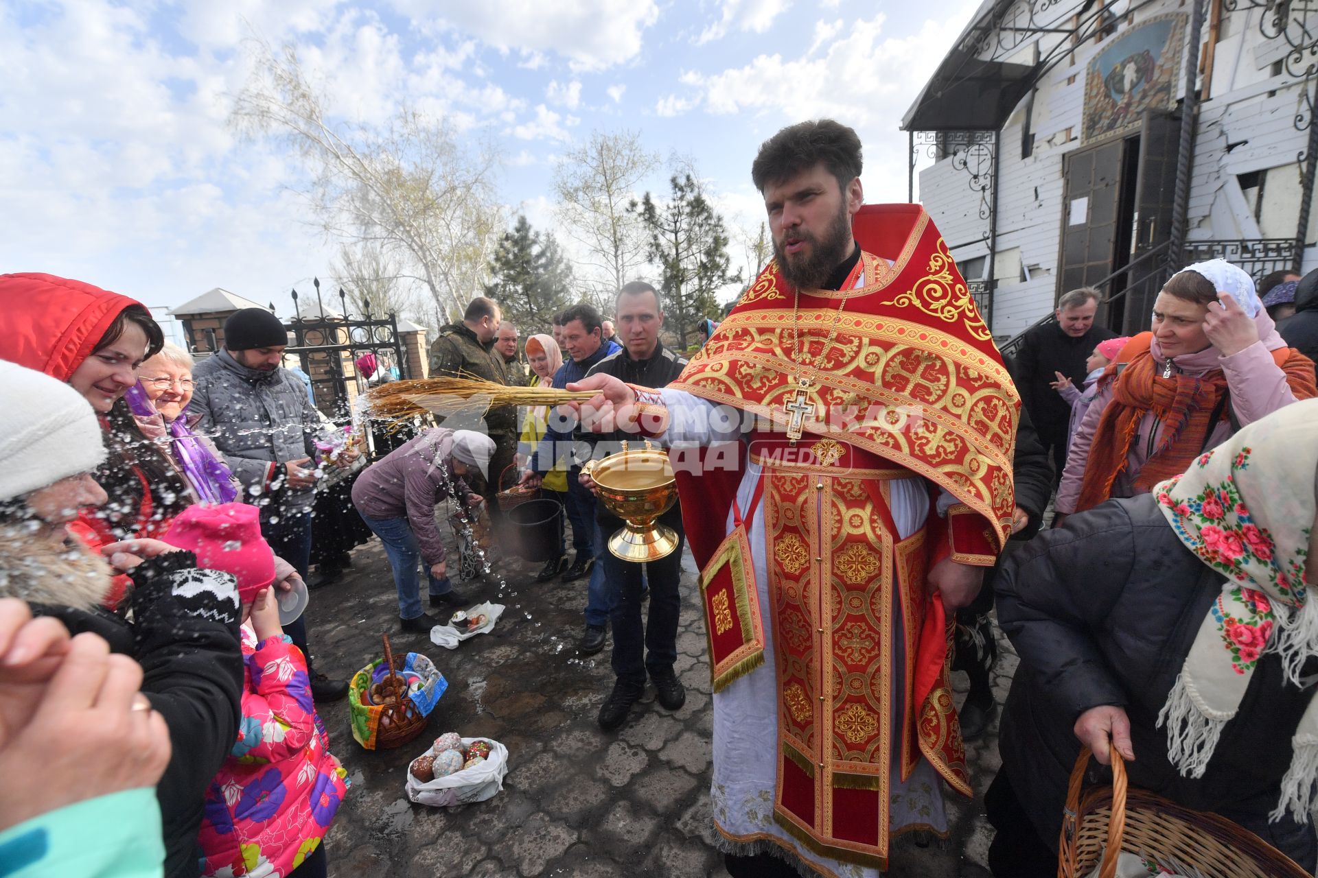 Волноваха, Донецкая народная республика. Верующие и священнослужитель  во время освящения пасхальных яиц и куличей после пасхальной службы в Православном храме.