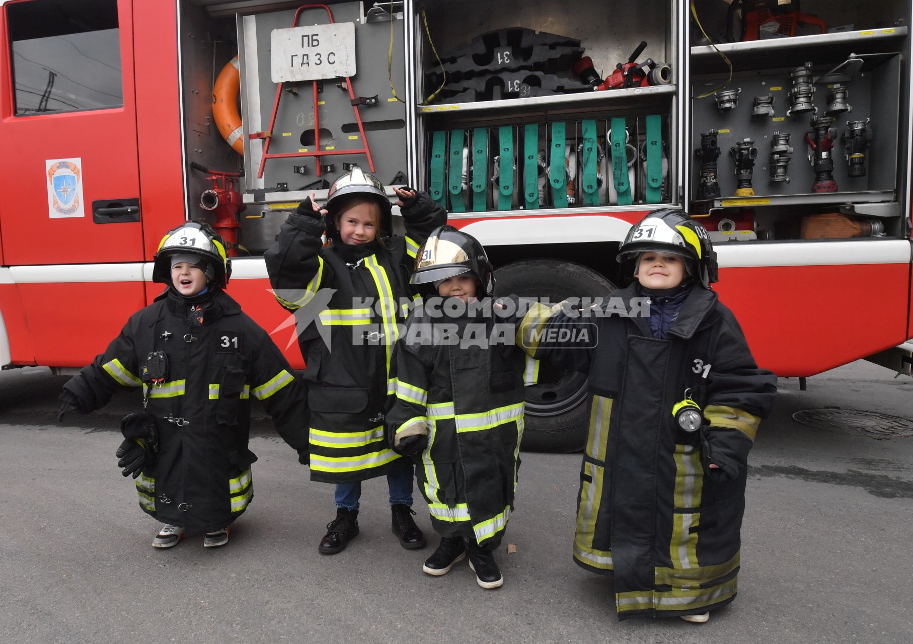 Москва. Дети в куртках пожарных во время  посещения Московской пожарной части №31 юными спасателями и их родителями в преддверии Дня гражданской обороны и МЧС России.