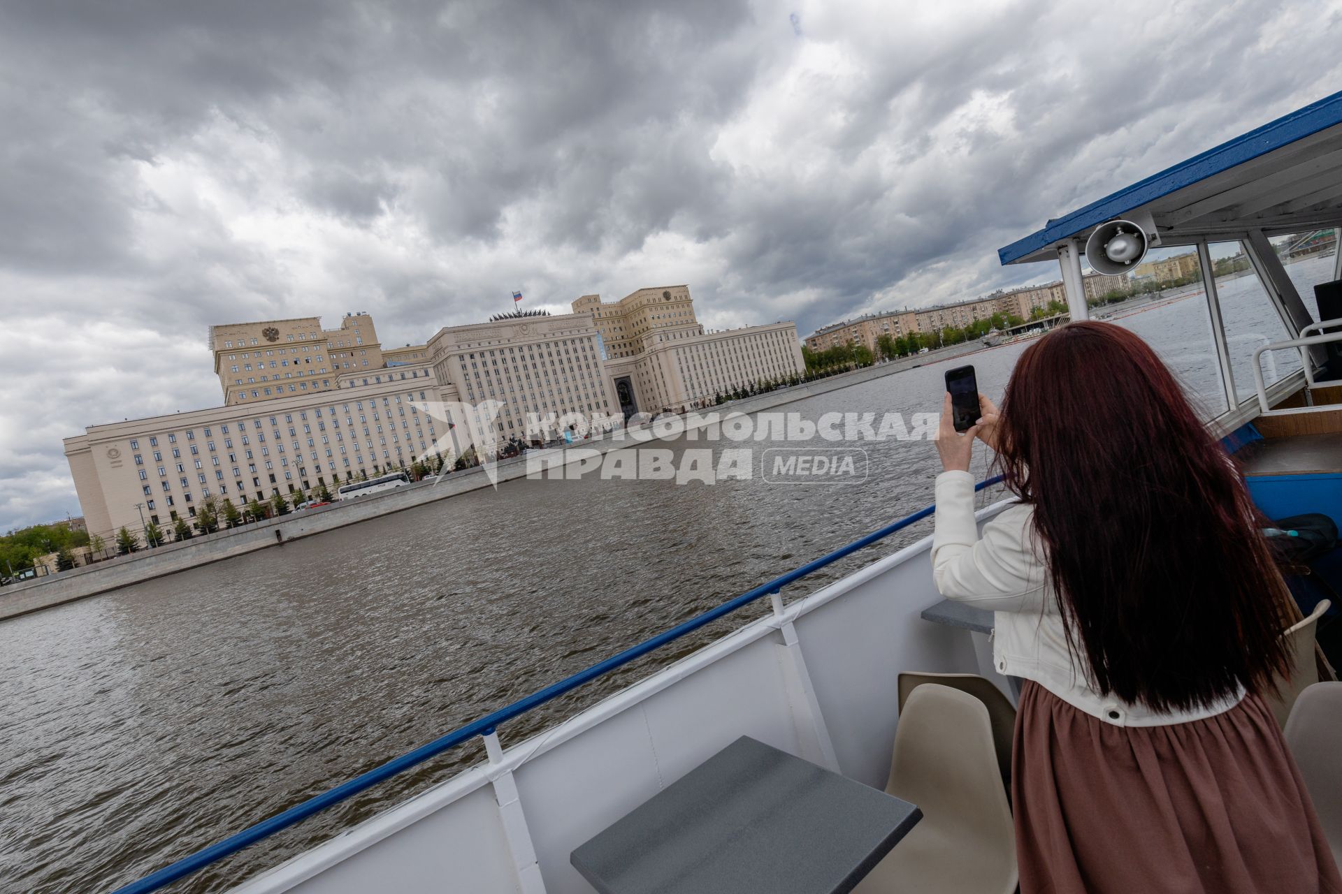 Москва. Девушка фотографирует здание Министерства обороны во время экскурсии на теплоходе.